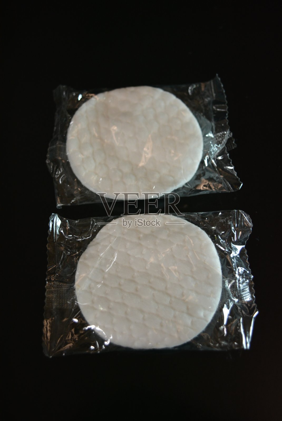 白色圆形海绵包裹在黑色光滑的表面上。照片摄影图片