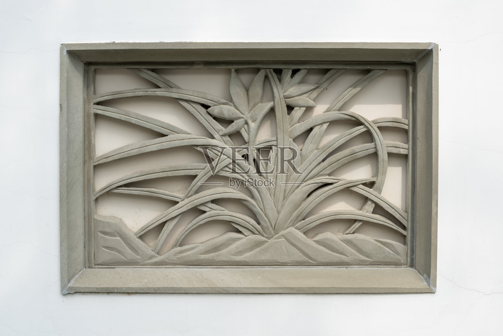 白色墙壁上的中国传统石质壁画，代表着植物。照片摄影图片