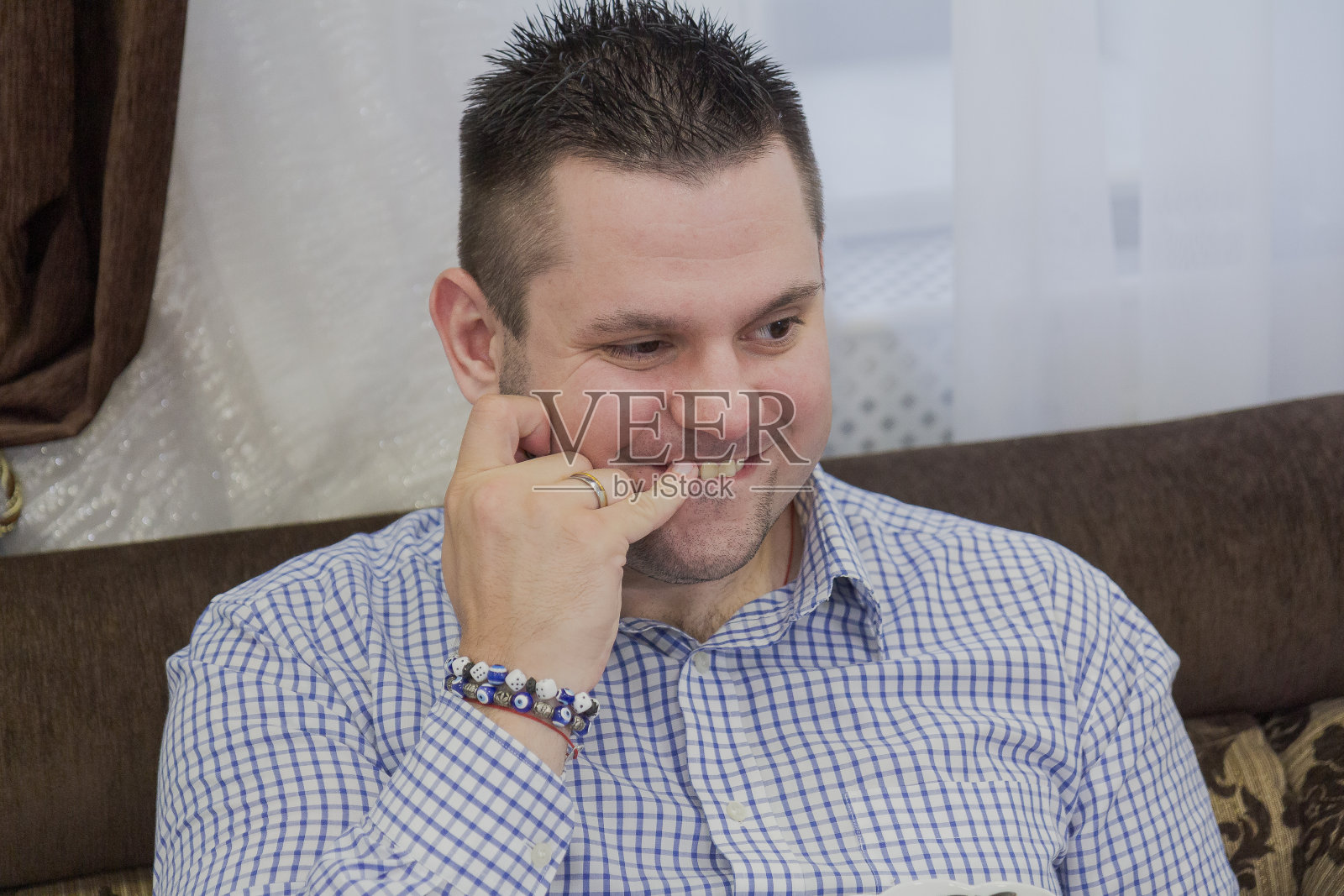 帅哥坐在沙发上吃瓜子照片摄影图片