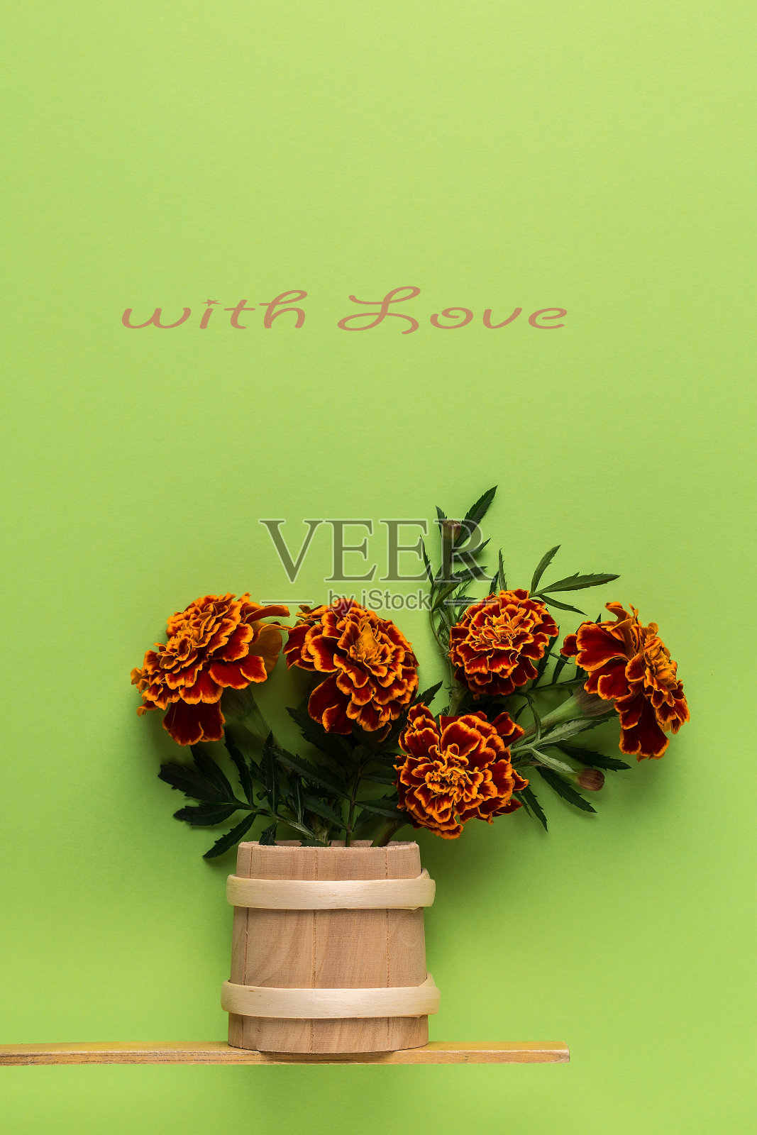 花束鲜花万寿菊在一个木制花瓶在绿色的背景。照片摄影图片