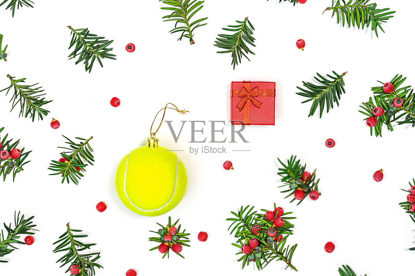 网球圣诞背景:圣诞装饰冷杉树枝与红色浆果和网球与红色礼盒，在白色的背景，孤立。照片摄影图片