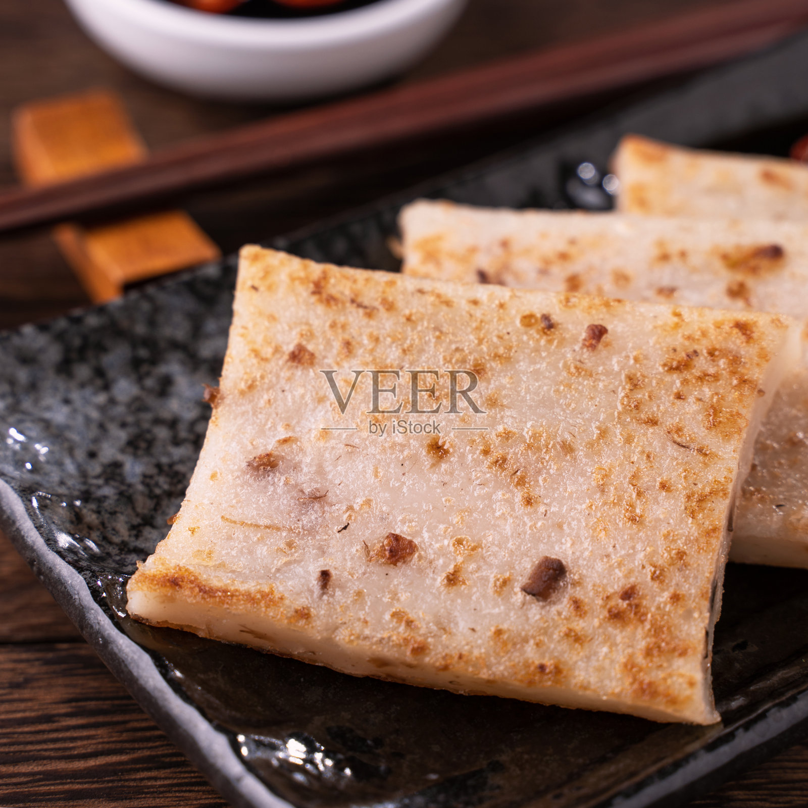 美味的萝卜糕，中国传统的地方菜萝卜糕在餐厅配酱油和筷子。照片摄影图片