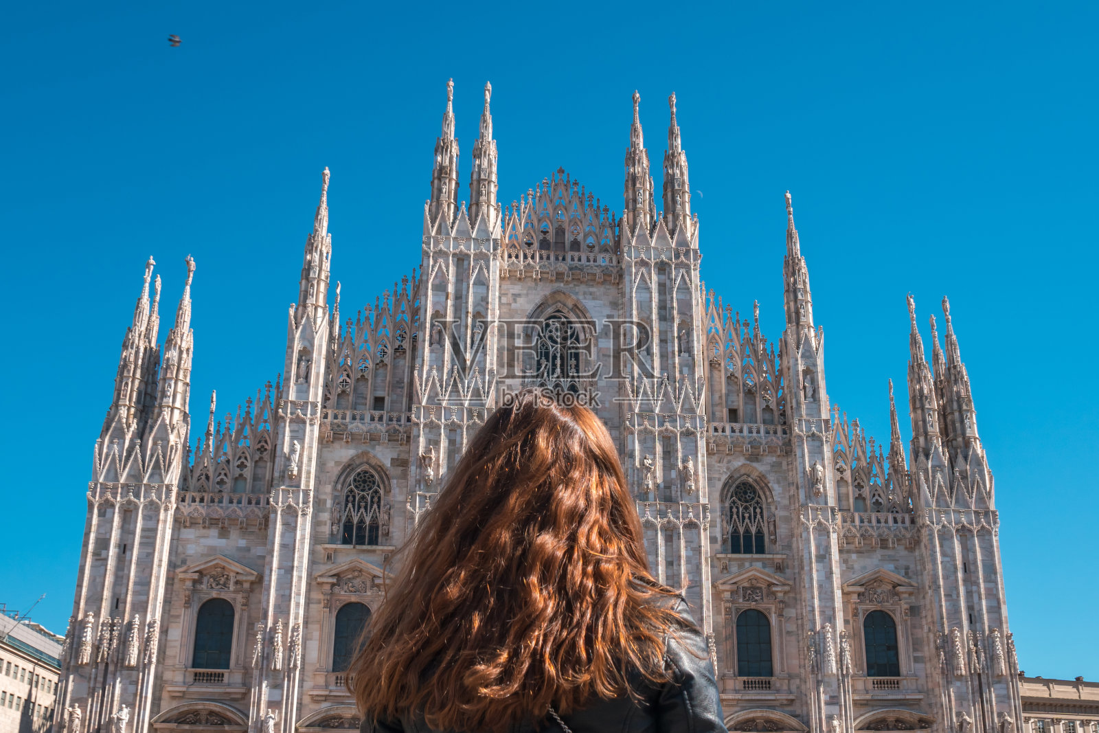 美丽的年轻女子在意大利米兰大教堂前摆姿势。照片摄影图片