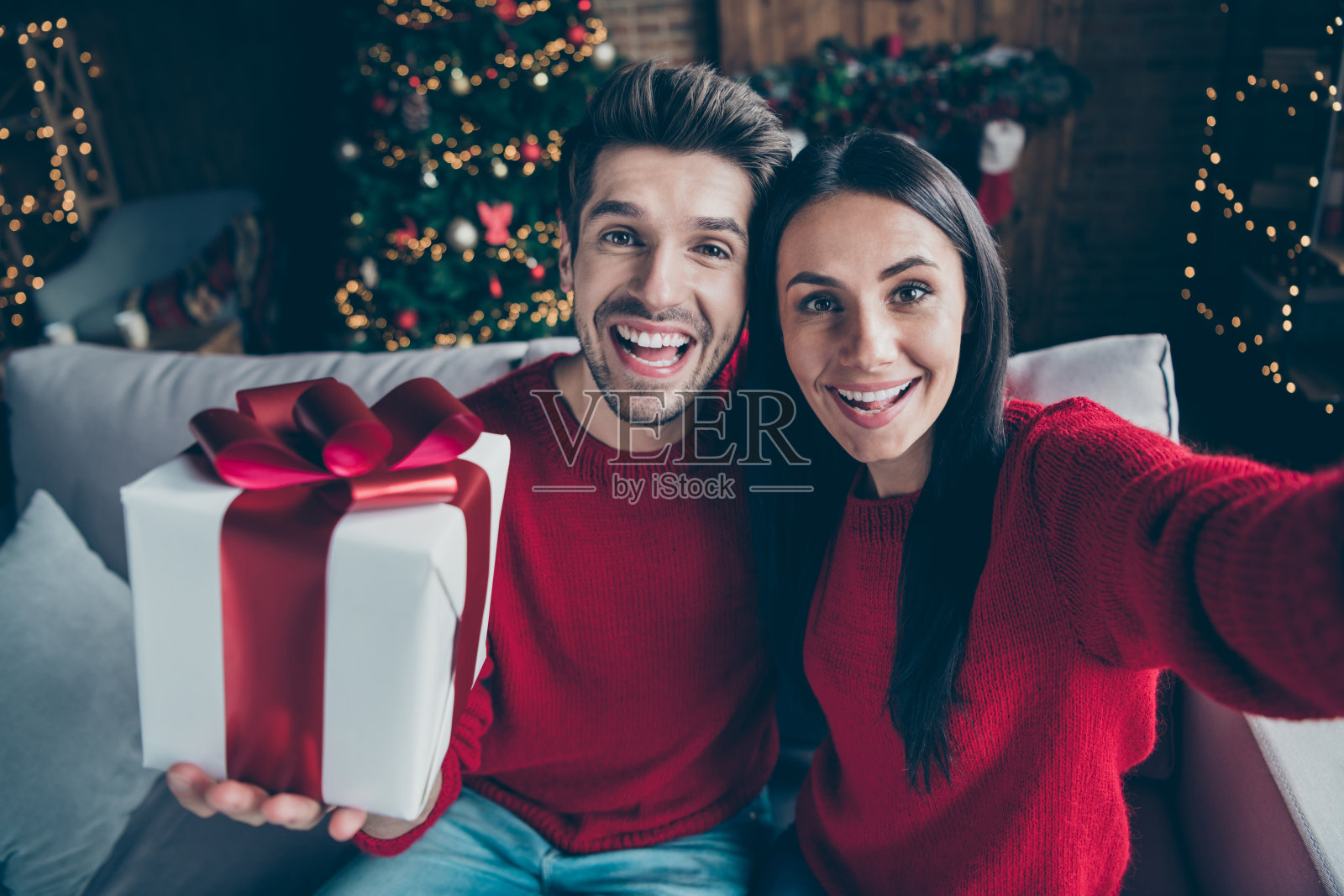 他的他她的自画像，她很好，有吸引力，可爱的，愉快的，愉快的，愉快的，愉快的，积极的已婚配偶握着手，在装饰阁楼工业风格的室内室内的礼物照片摄影图片