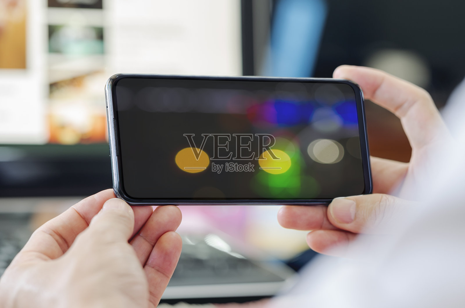 近距离观看男子手持智能手机与散景图像屏幕。照片摄影图片