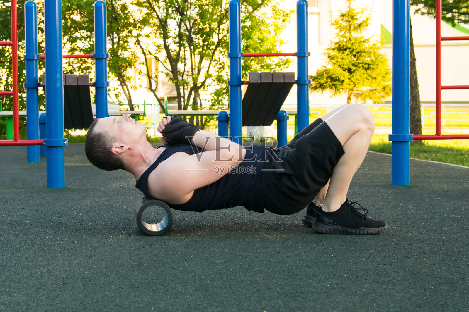 一个戴着黑手套的男人，在户外做运动，做空中飞人按摩，滚轮照片摄影图片