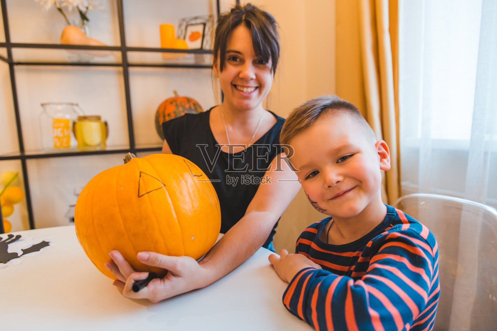 妈妈和儿子一起在家做南瓜头照片摄影图片