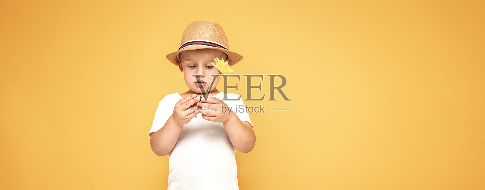 快乐的孩子戴着夏天的帽子微笑着。照片摄影图片