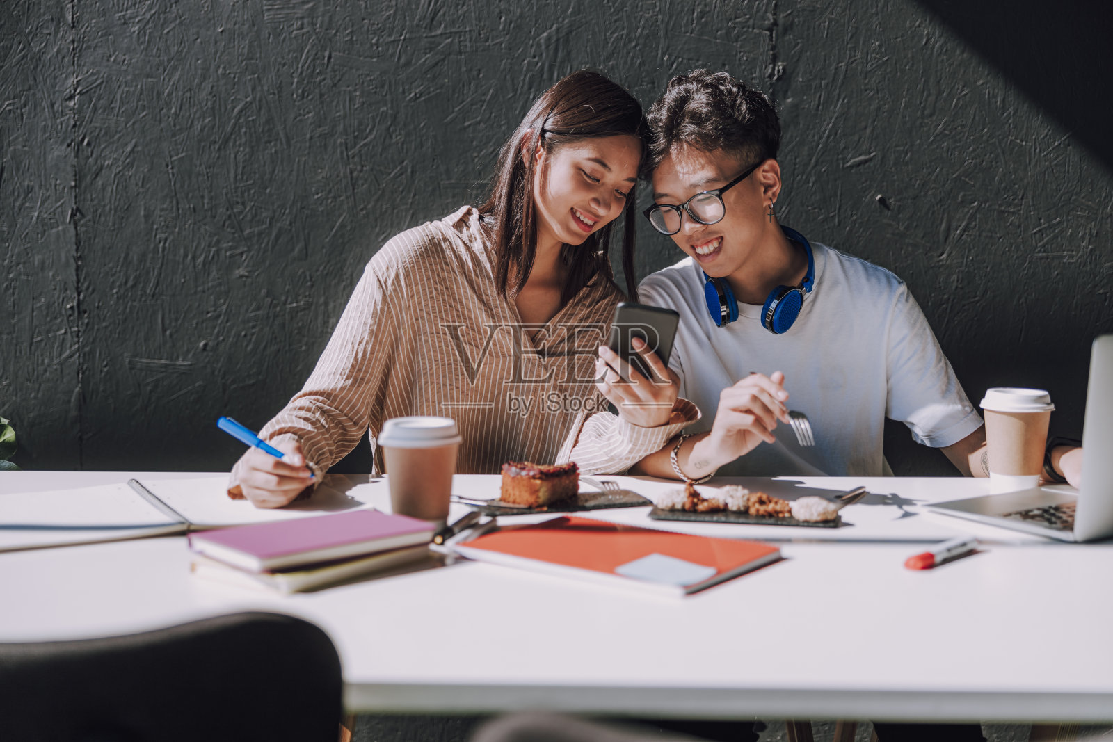 漂亮的亚洲女人拿着智能手机在咖啡馆照片摄影图片