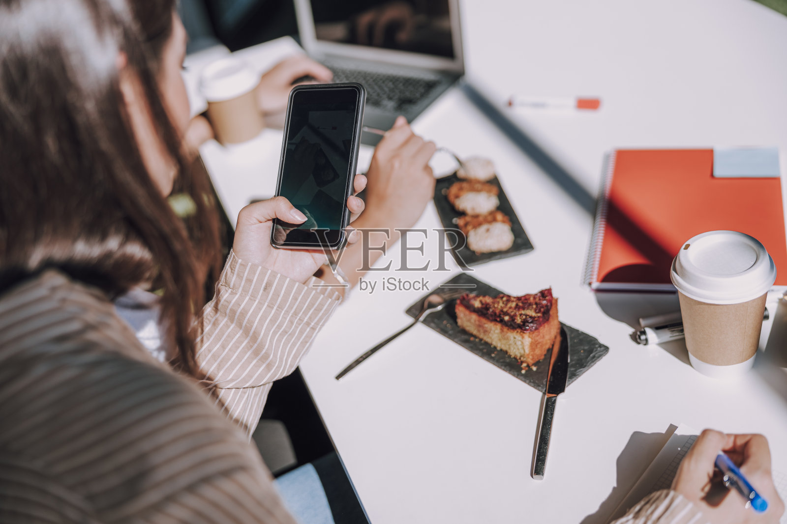年轻女子正在用手机拍照照片摄影图片