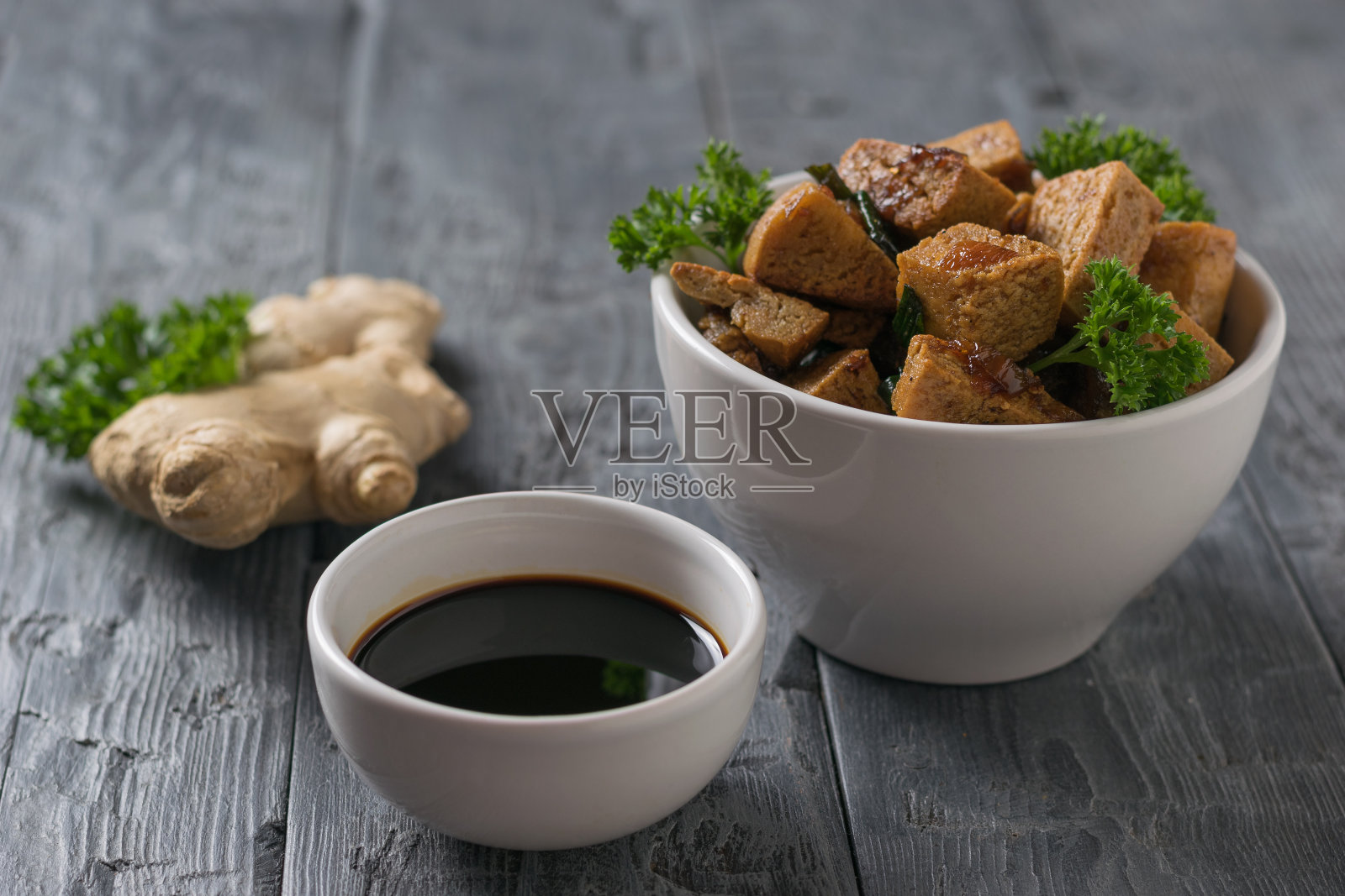 桌上放着姜根、烤豆腐、奶酪和酱油。照片摄影图片