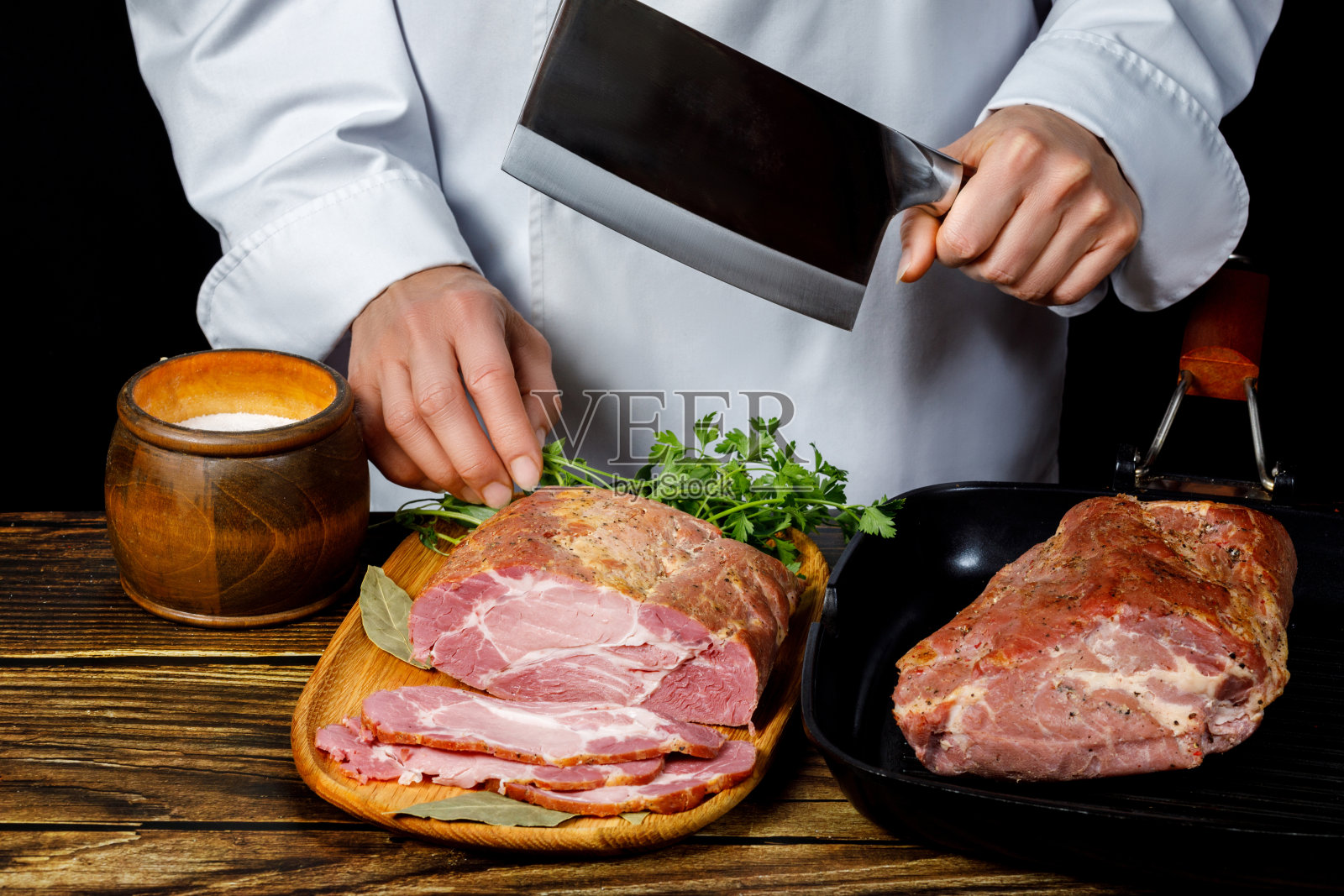 厨师要把火腿切成片。照片摄影图片