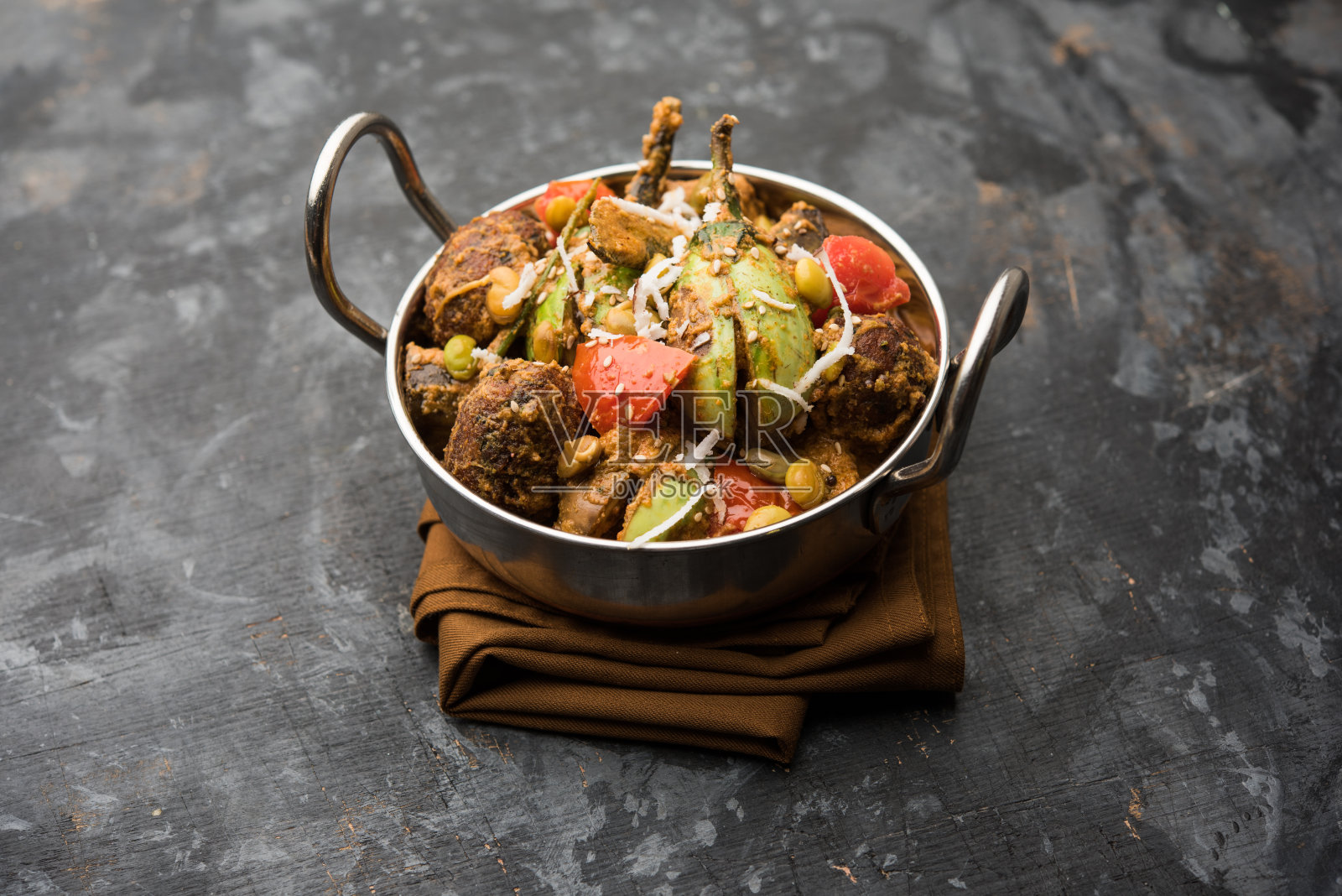 unhiyu是古吉拉特混合蔬菜菜，印度苏拉特的特色。盛在碗里，有或没有poori照片摄影图片