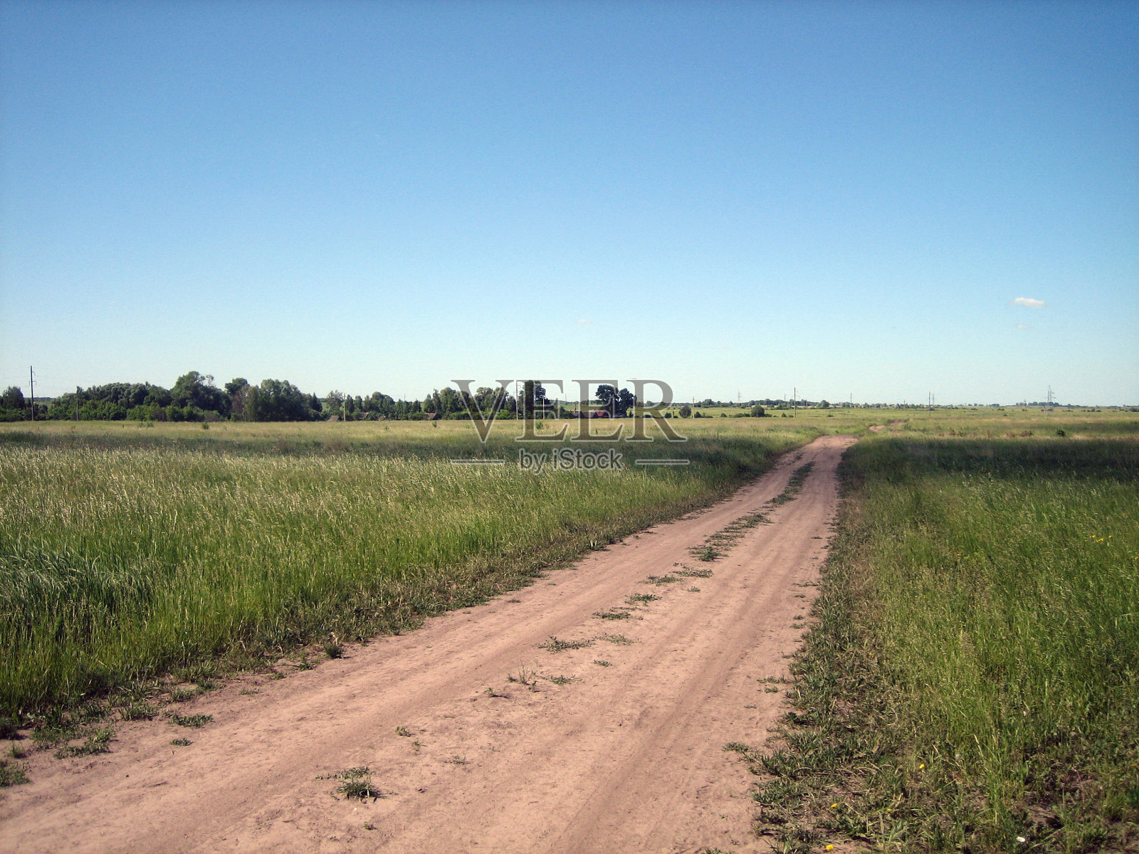 干燥的泥土车辙形成了一条平坦笔直的乡村道路