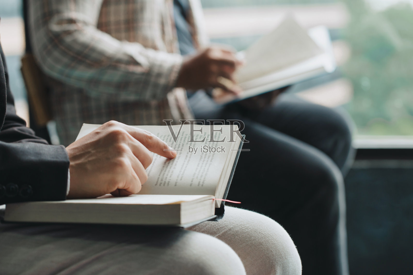 人们在读圣经。两个人在读一本书。老师和学生一起阅读。照片摄影图片