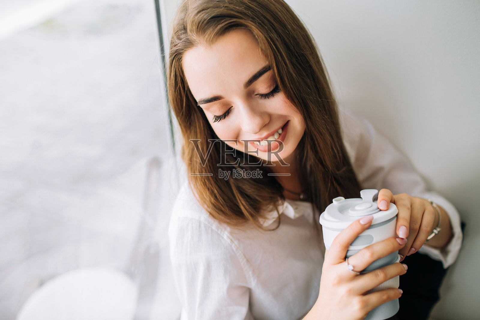 一个年轻女人在早上喝咖啡的特写。照片摄影图片