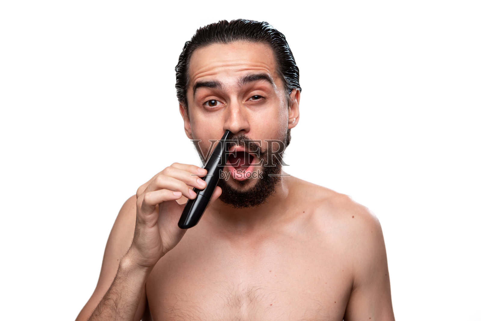 英俊的留胡子的男人用力量修剪鼻子的头发裸露孤立在白色的背景。早晨护理和剃须的概念。照片摄影图片