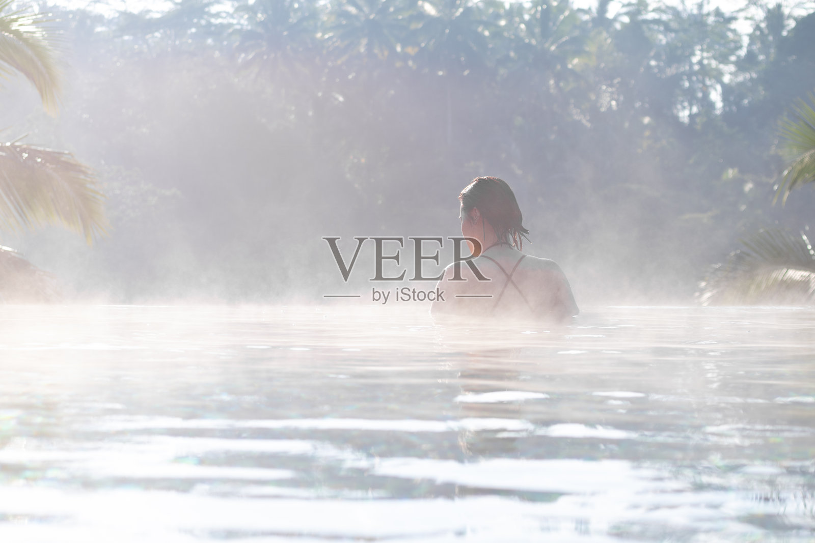 一个年轻女子在无边泳池里放松照片摄影图片