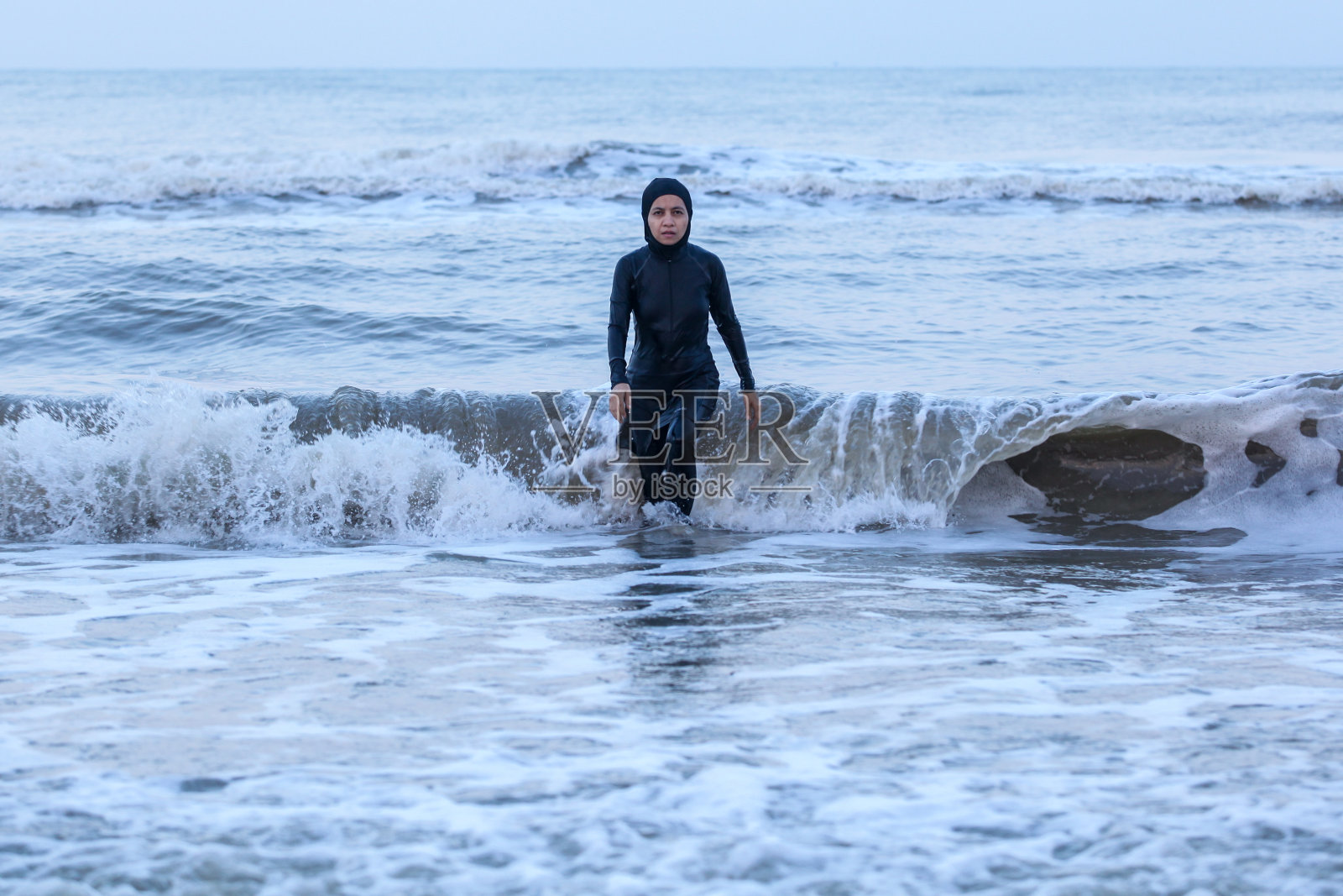 在海浪中行走照片摄影图片