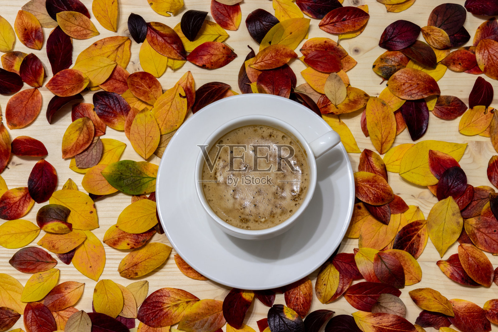桌上放着一杯咖啡和秋叶照片摄影图片