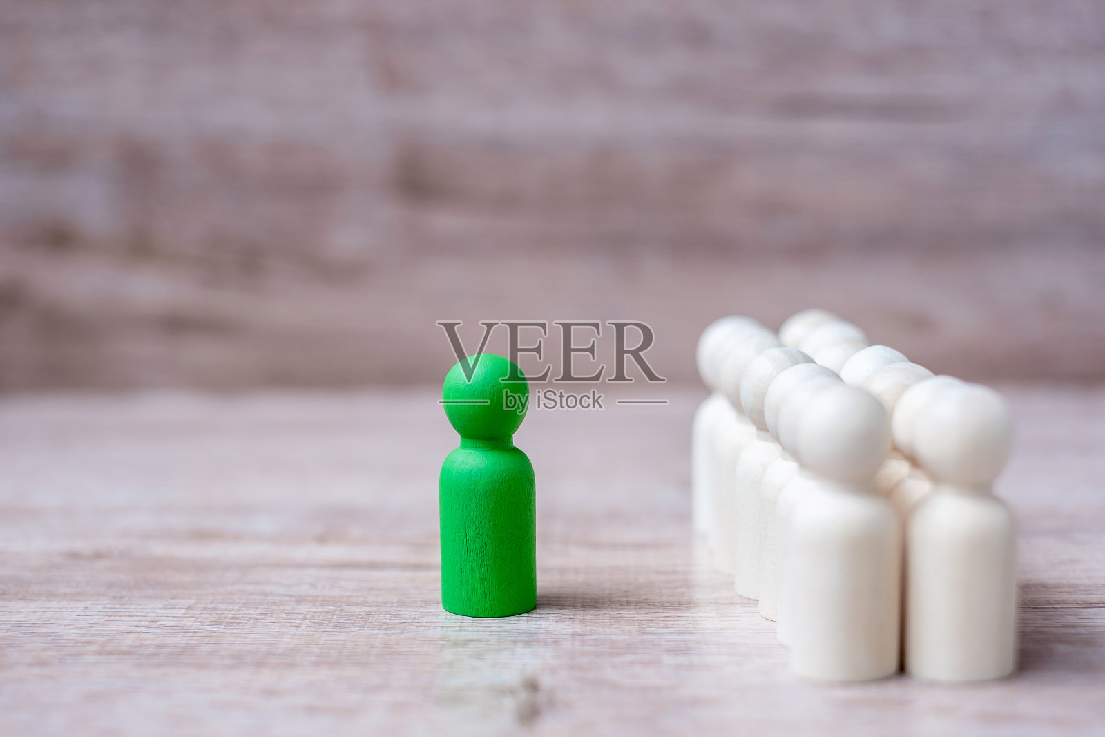 绿色领袖商人和一群木头人。领导力、业务、团队、团队合作和人力资源管理理念照片摄影图片