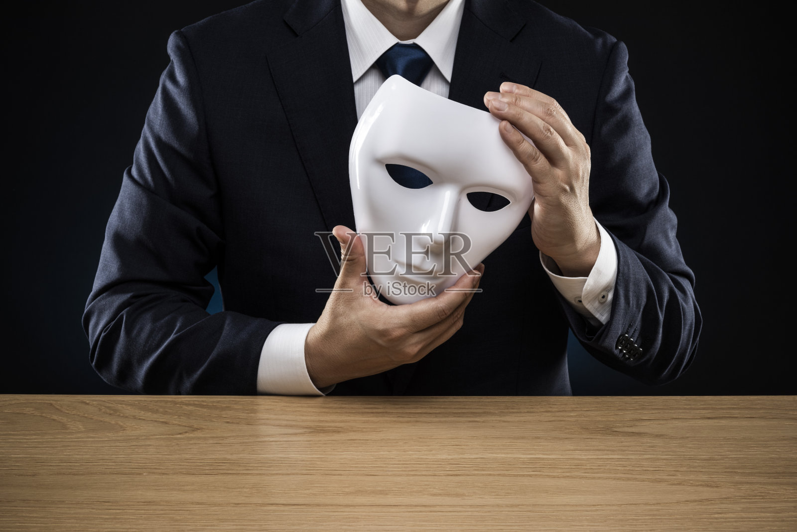 穿西装的人摘下了面具照片摄影图片