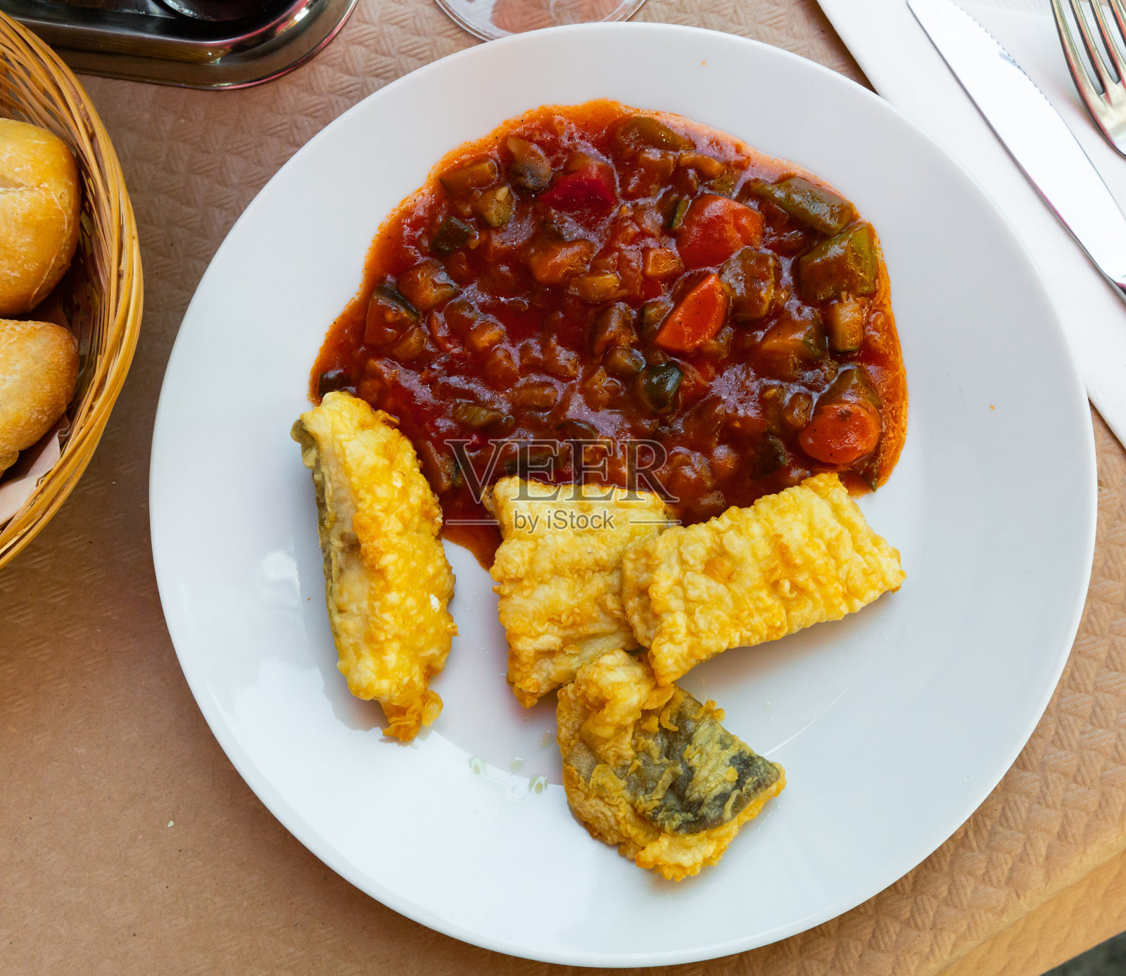 用面糊煎鳕鱼，配炖蔬菜杂烩照片摄影图片