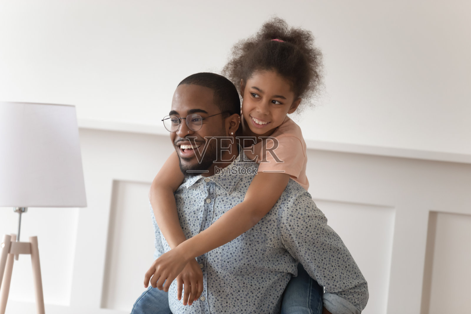 微笑的父亲让小女儿骑在背上照片摄影图片