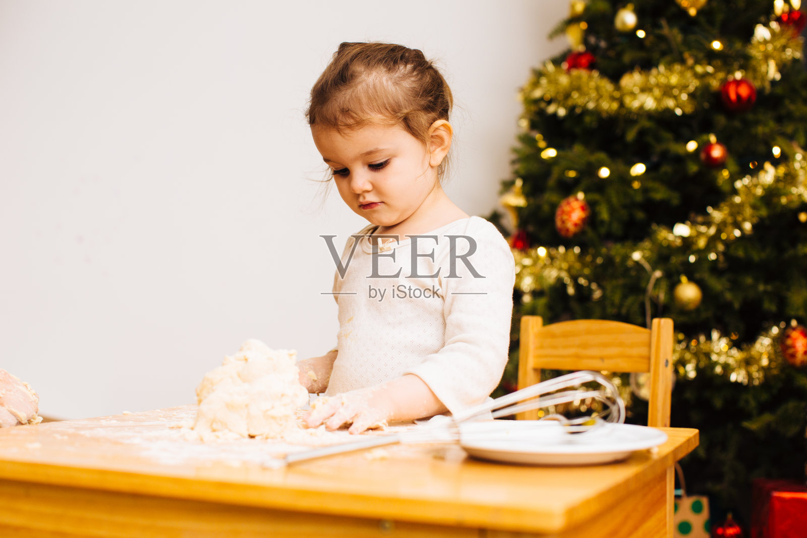蹒跚学步的小女孩正在揉面团做圣诞甜点照片摄影图片