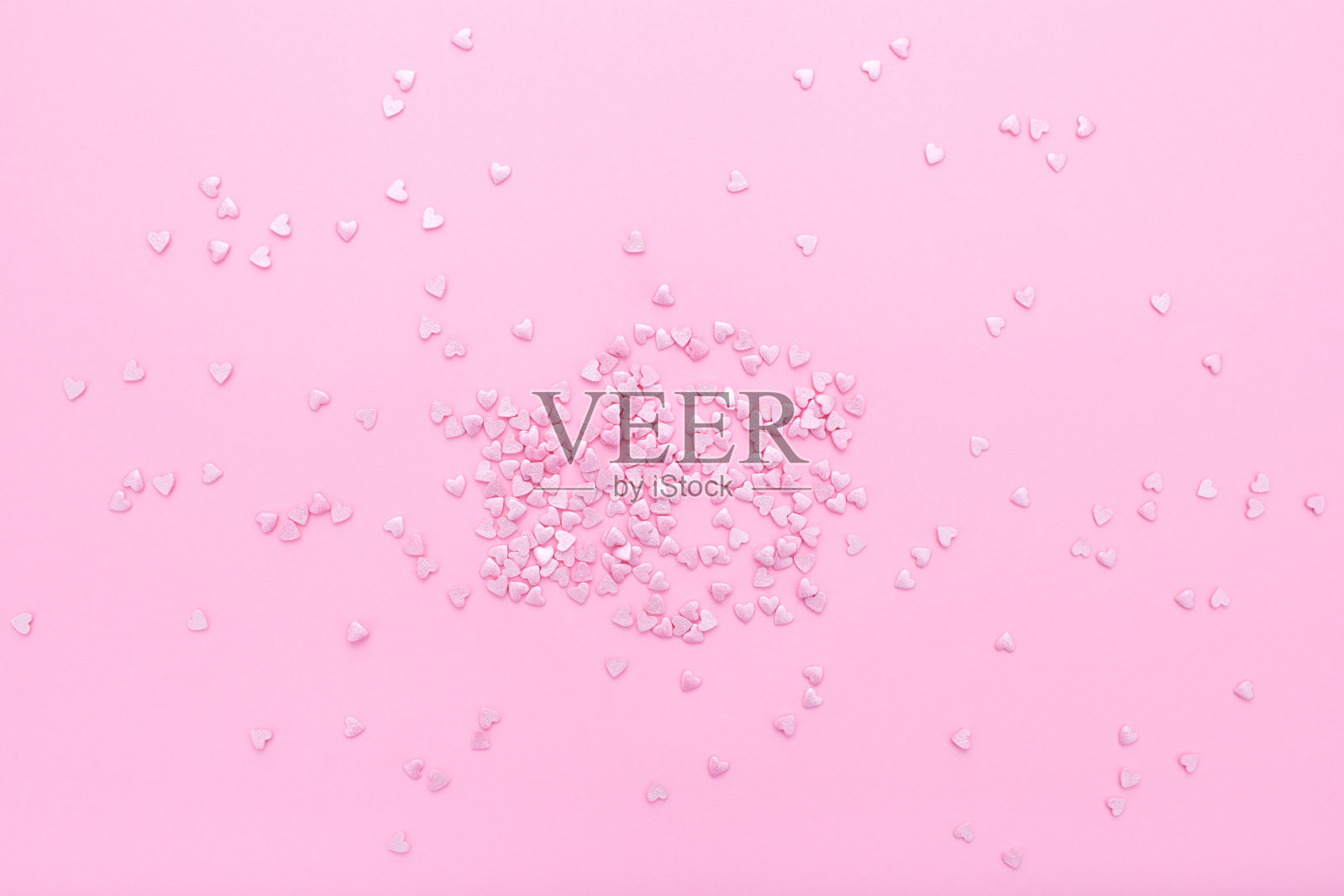 粉红色的背景。粉红色的心在粉红色的背景上。心洒。照片摄影图片