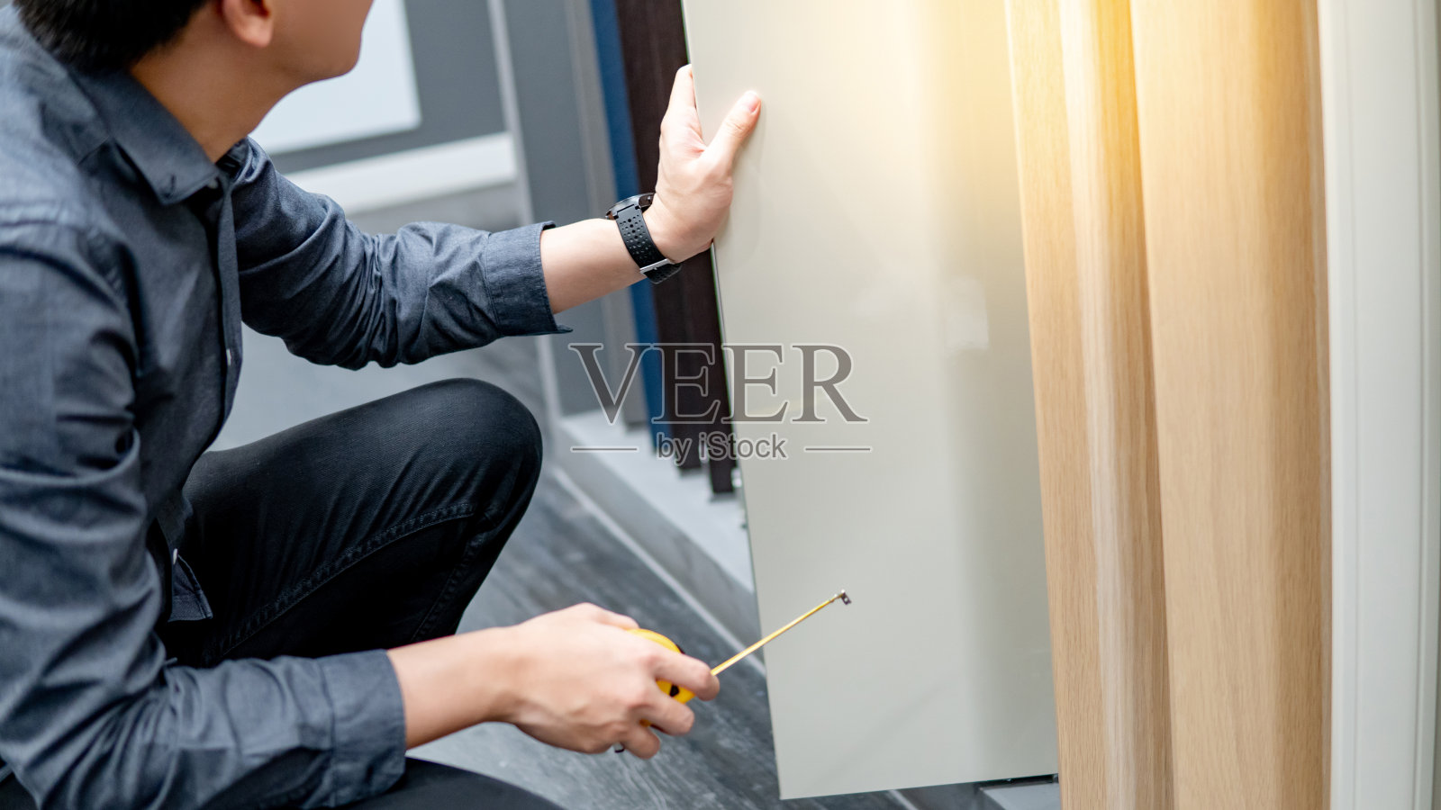 亚洲人用卷尺测量橱柜材料照片摄影图片