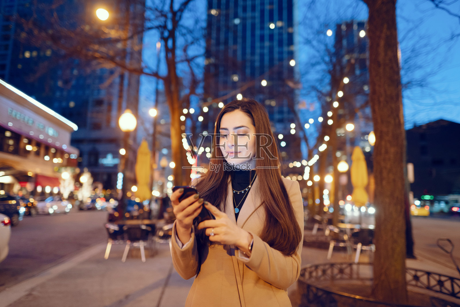 时尚女孩走在夜晚的城市里照片摄影图片