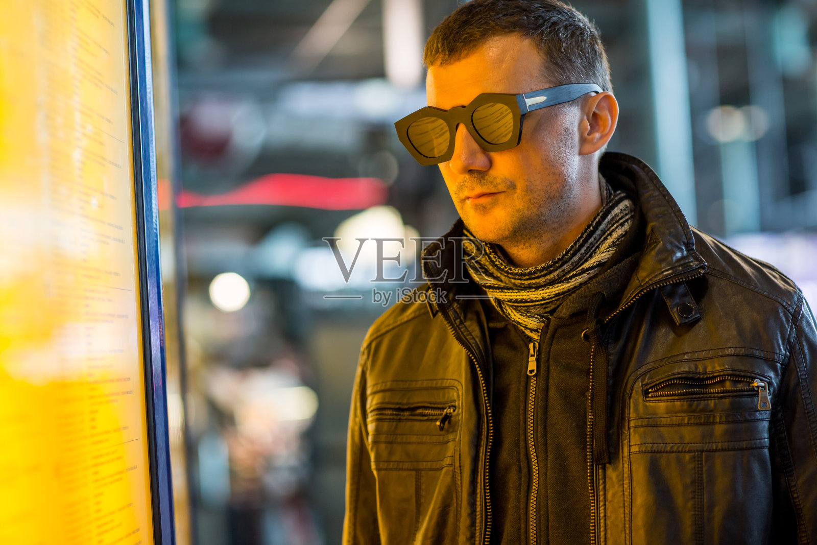 年轻人在火车站或机场附近显示时刻表。旅游的概念照片摄影图片