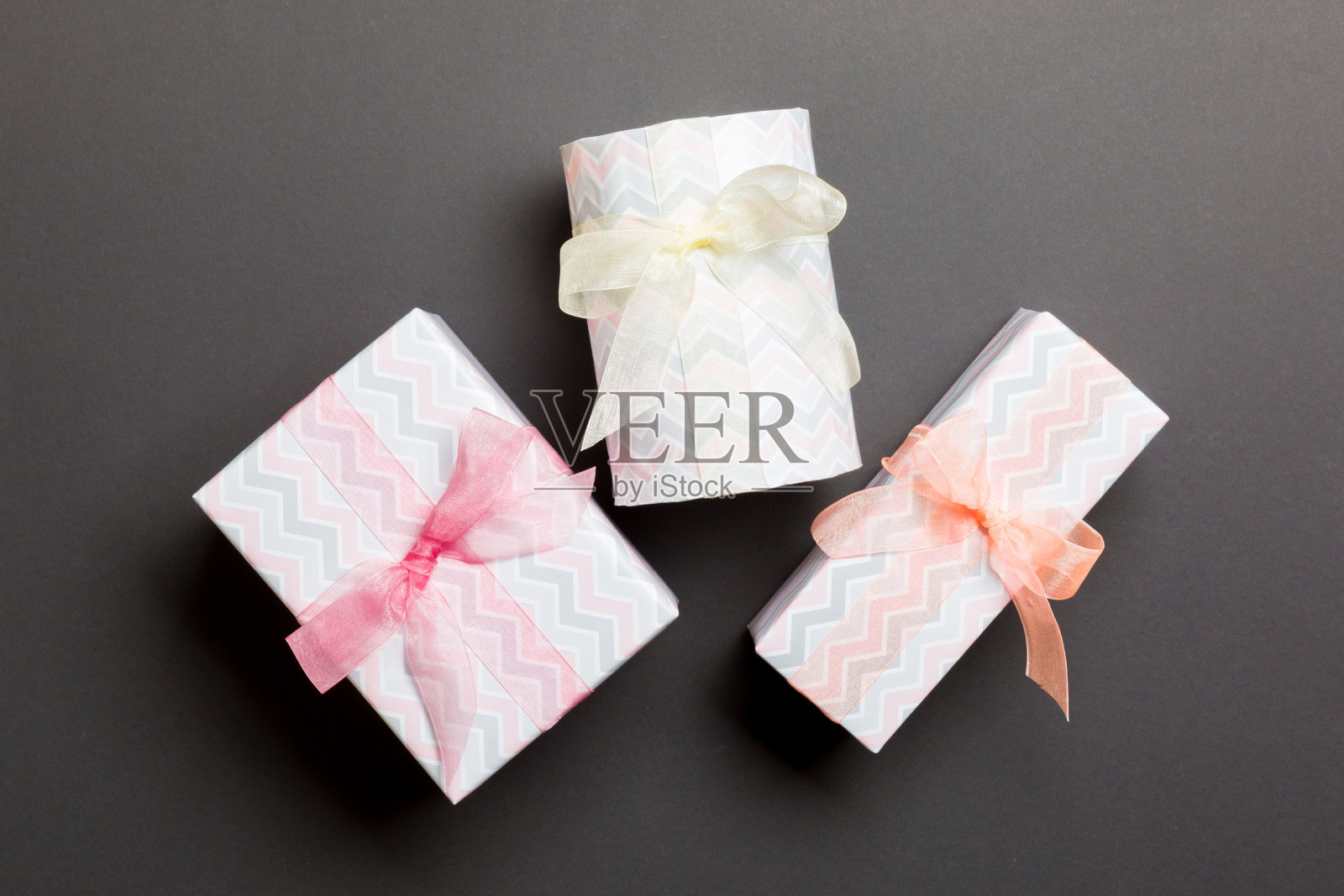 礼物盒与彩色的弓在手中为圣诞节或新年日的黑色背景，俯视图照片摄影图片