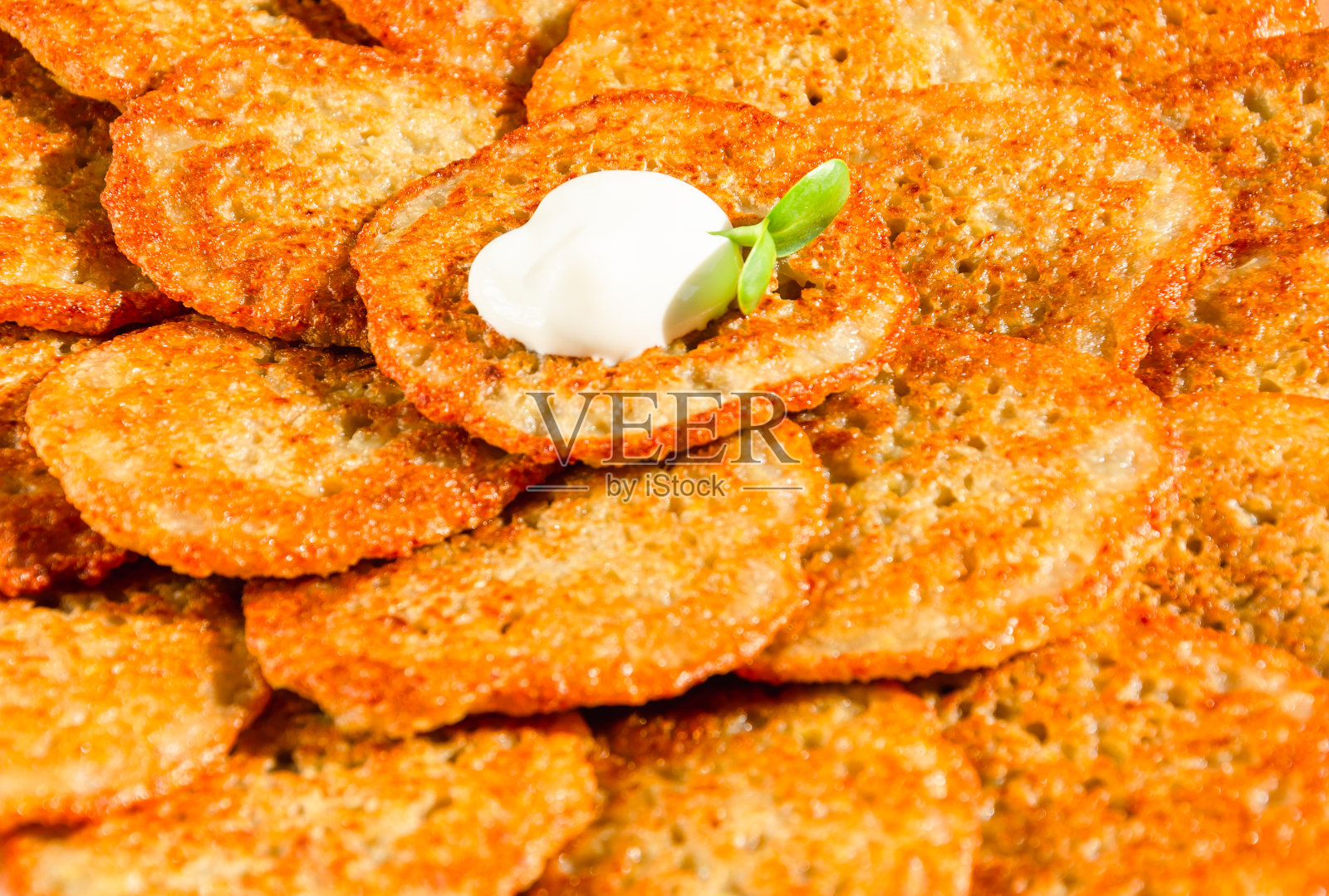 自制的土豆煎饼、土豆饼、土豆煎饼或油炸饼配酸奶油和向日葵芽。光明节的传统食物。特写镜头照片摄影图片