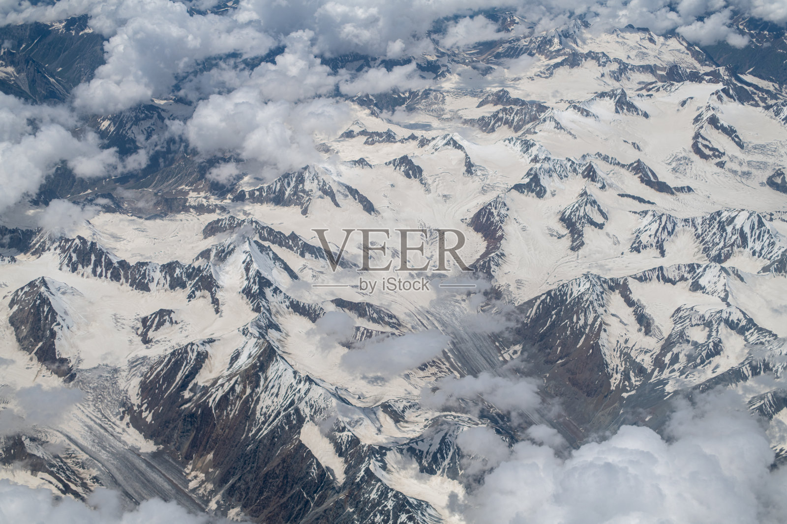 顶视图最高的雪山和云。照片摄影图片