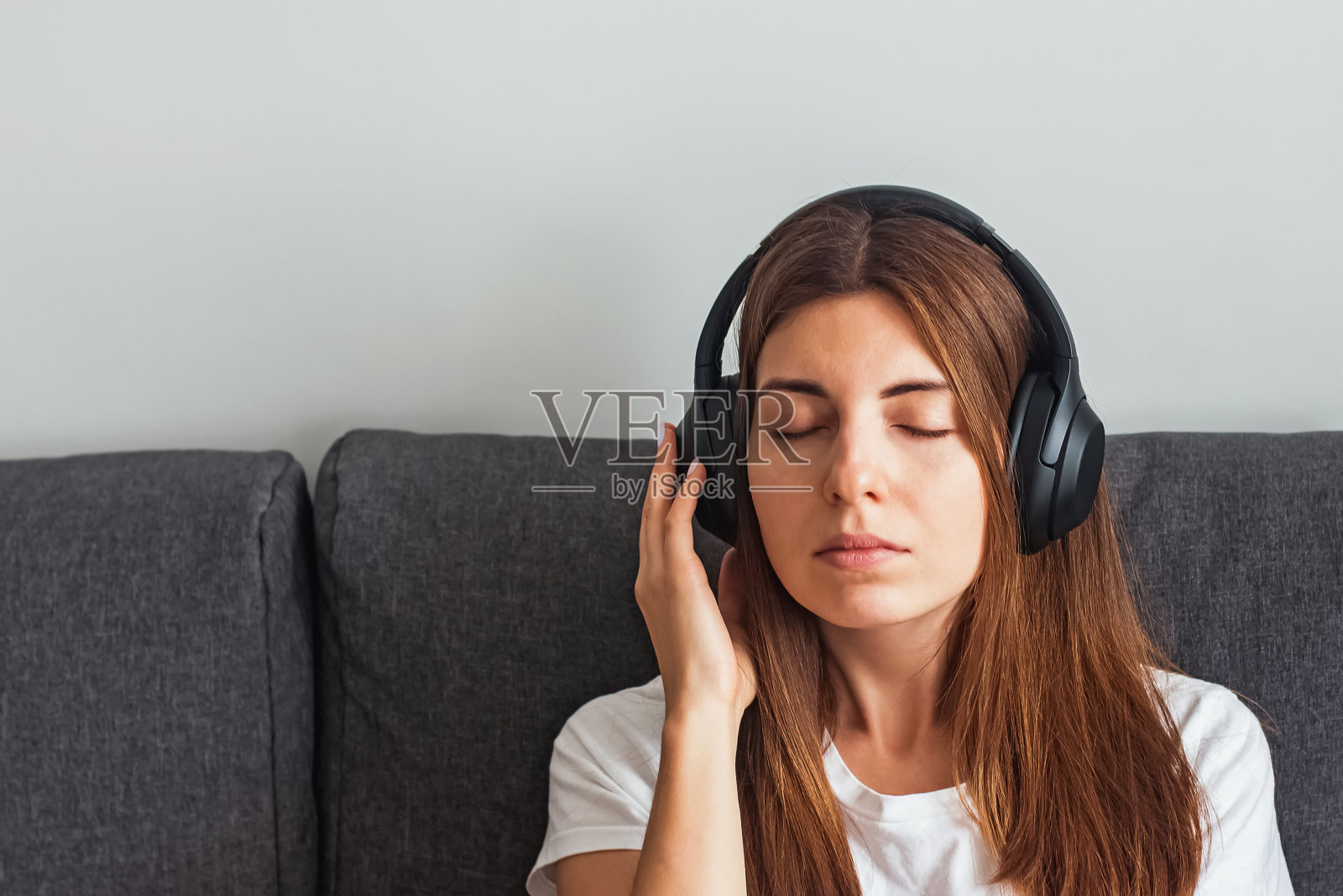 年轻女子戴着大耳机在家听着平静的音乐照片摄影图片