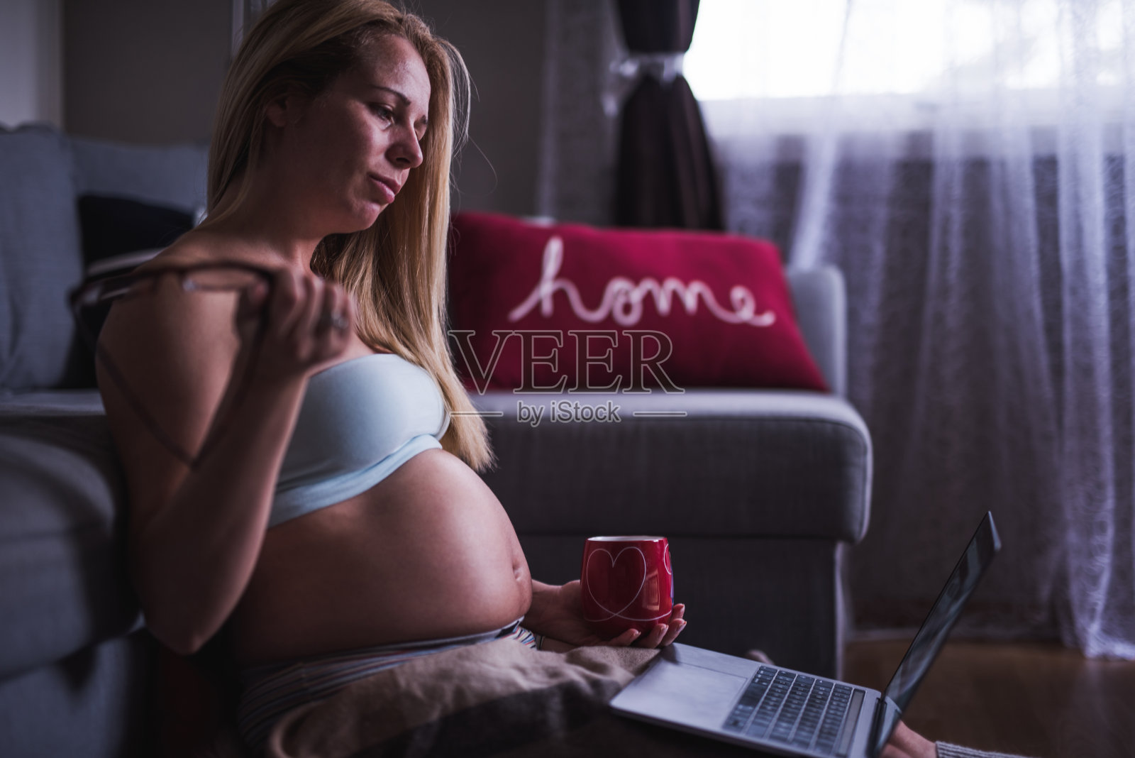 年轻的孕妇在家经营小生意。照片摄影图片