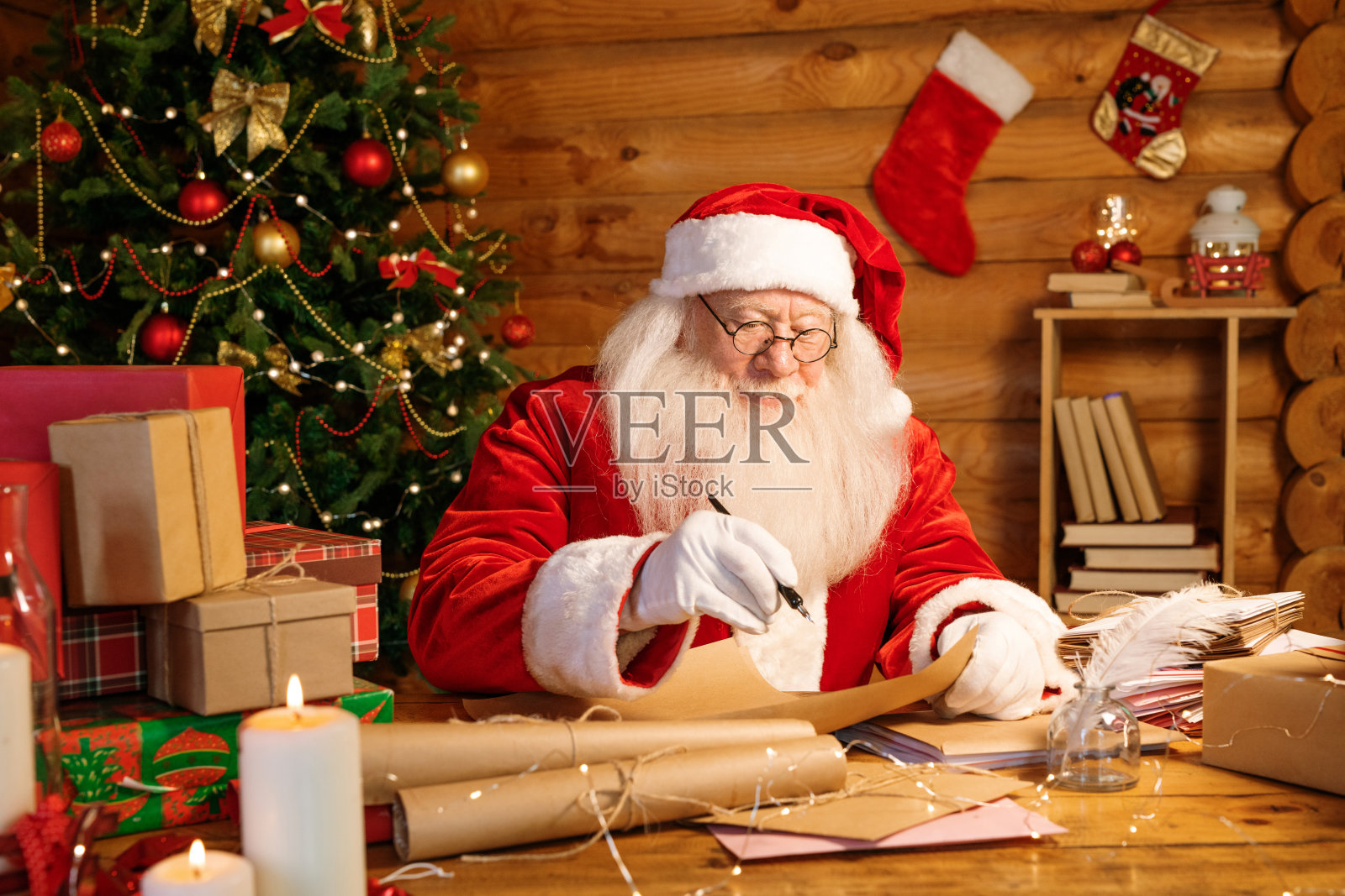 白胡子的圣诞老人拿着笔在纸上写着信照片摄影图片