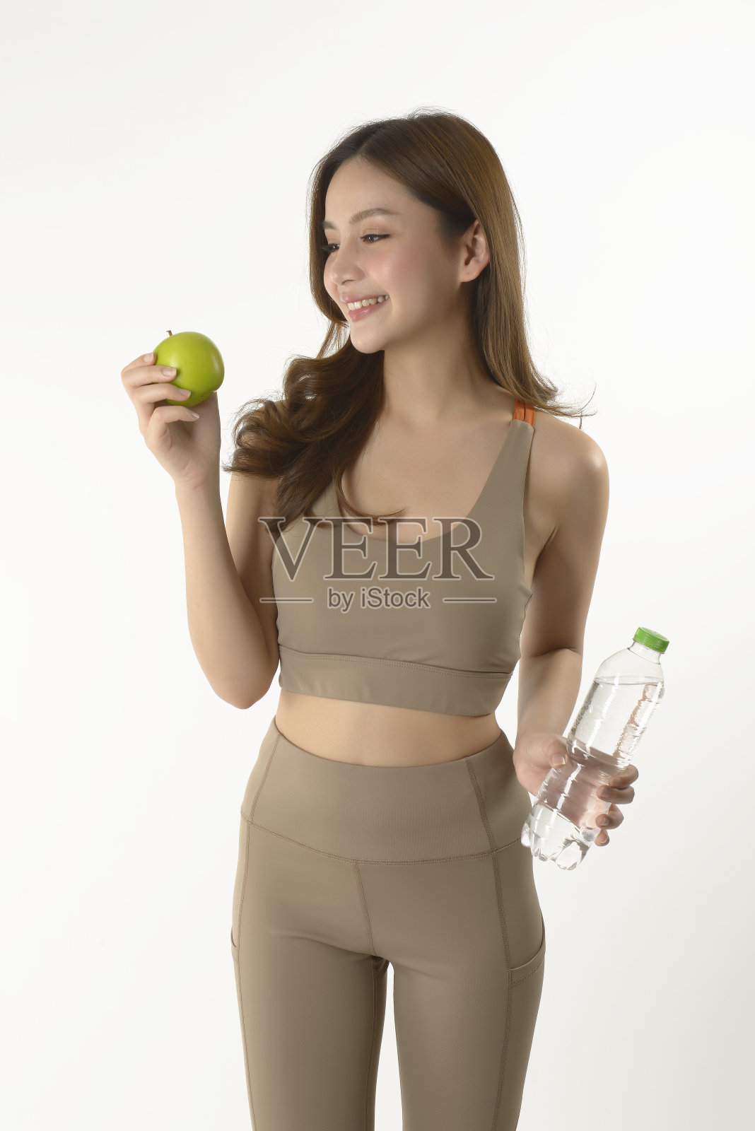 漂亮的亚洲女人与苹果和水在白色的背景。照片摄影图片