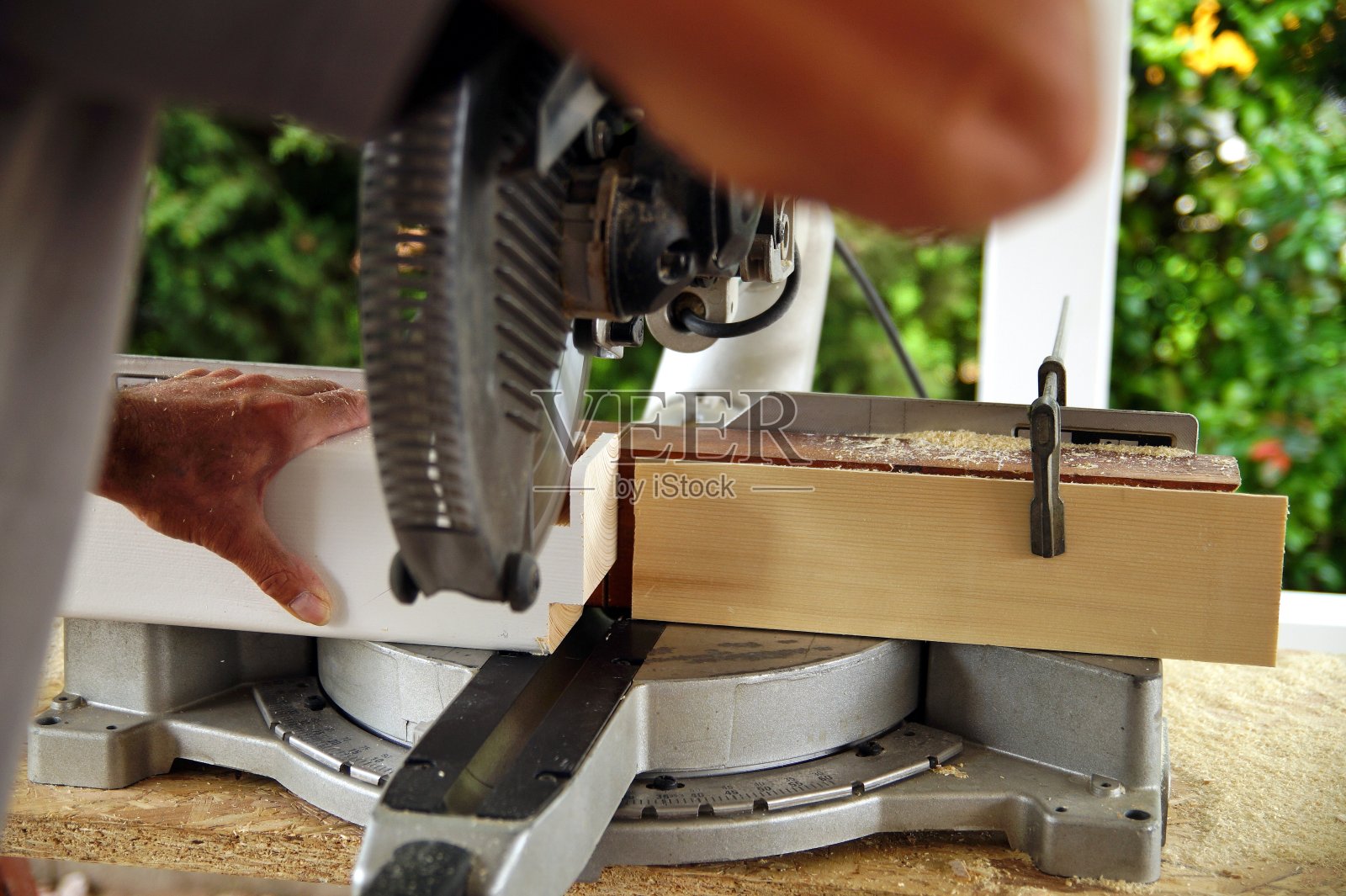 木匠用圆锯切割木梁的木匠。木工、木工生产。室外建筑用云杉木梁，车库用木梁。照片摄影图片