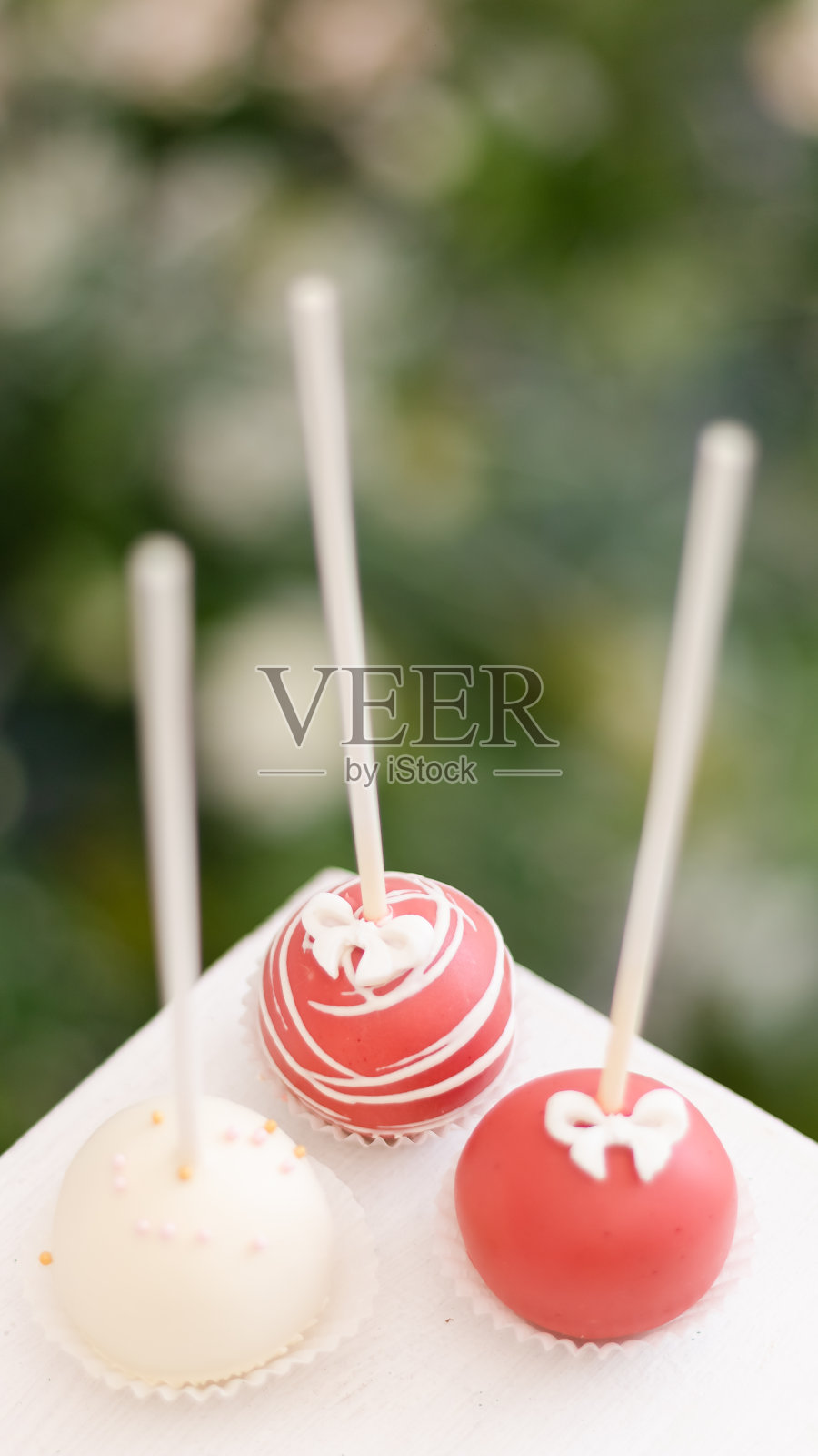 绿色背景上有三个棒棒糖蛋糕照片摄影图片