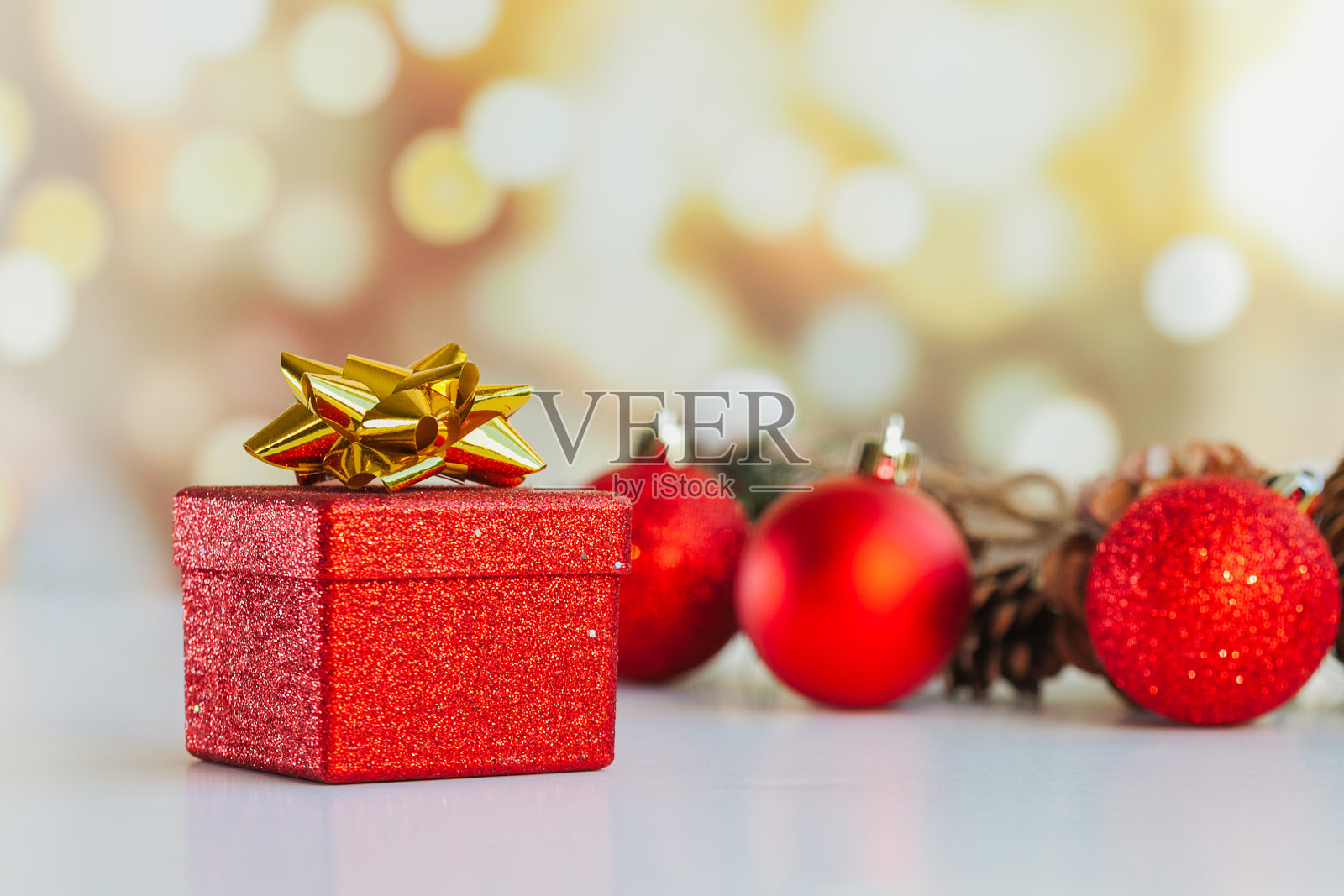 圣诞或新年装饰品，红色礼品盒，松果和球与散景灯照片摄影图片