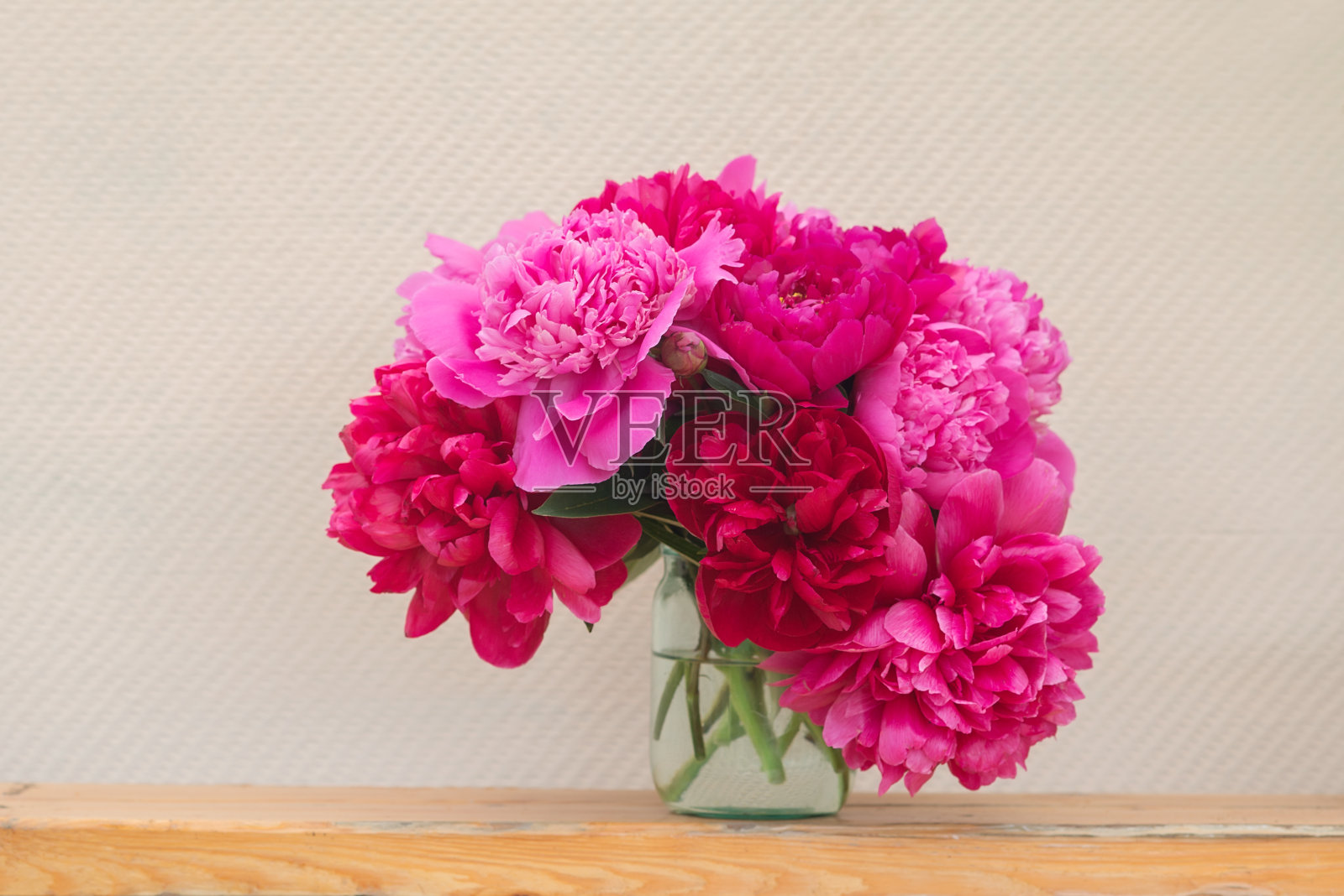 木板上有一束粉红色的牡丹。照片摄影图片