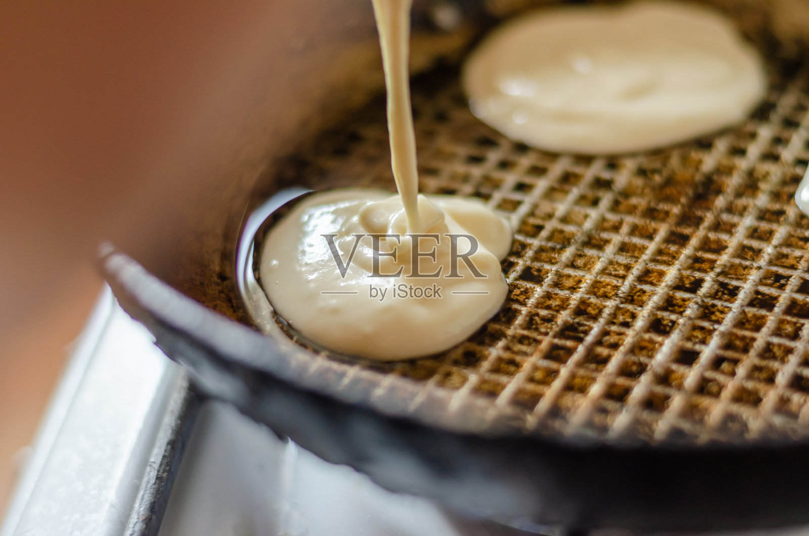 孩子上学前，妈妈在厨房里为孩子炸美味的油饼当早餐。照片摄影图片