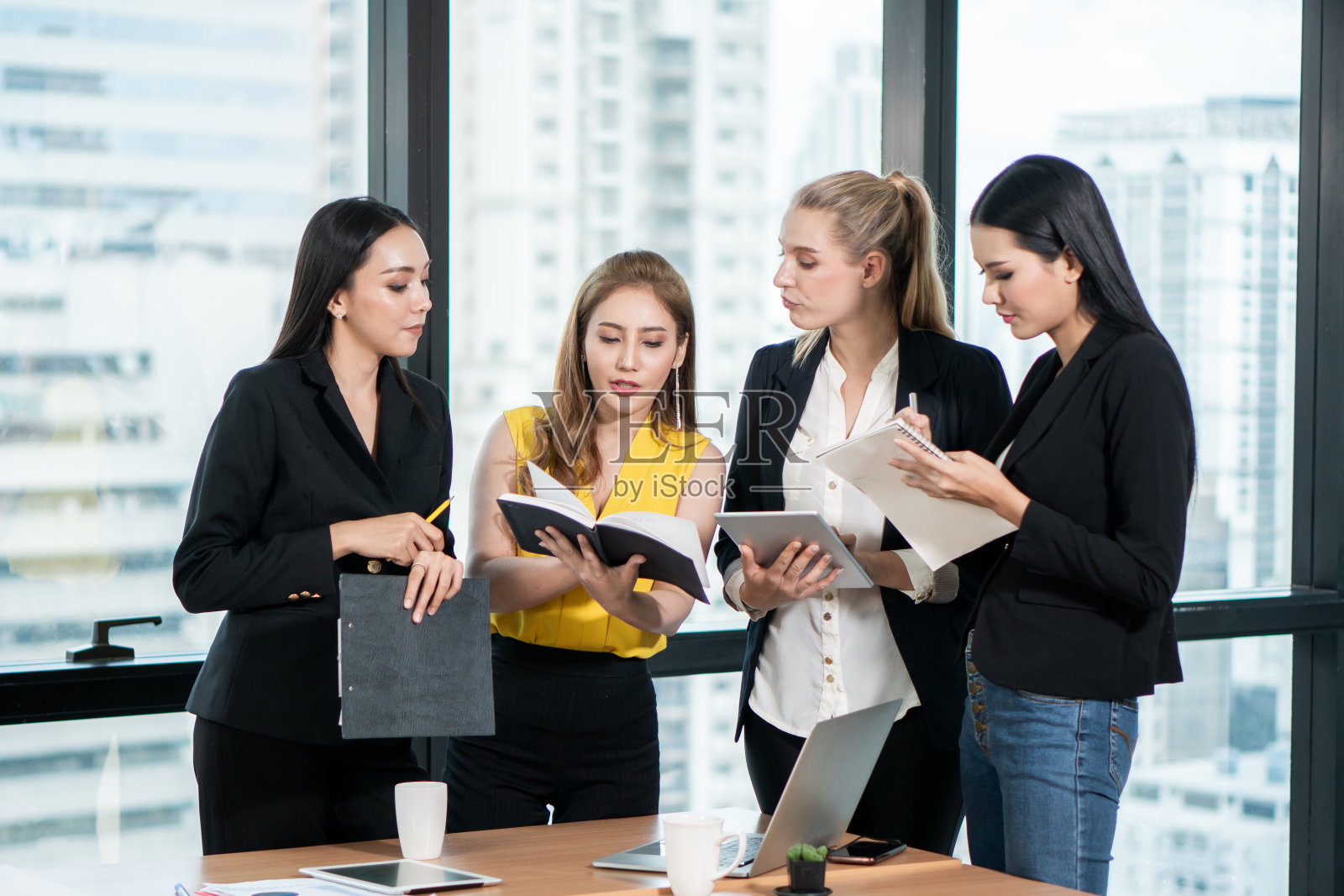 一群亚洲商务女性在办公室用笔记本电脑开会。市场团队头脑风暴在工作空间一起工作。公司同事讨论财务顾问。会议照片摄影图片