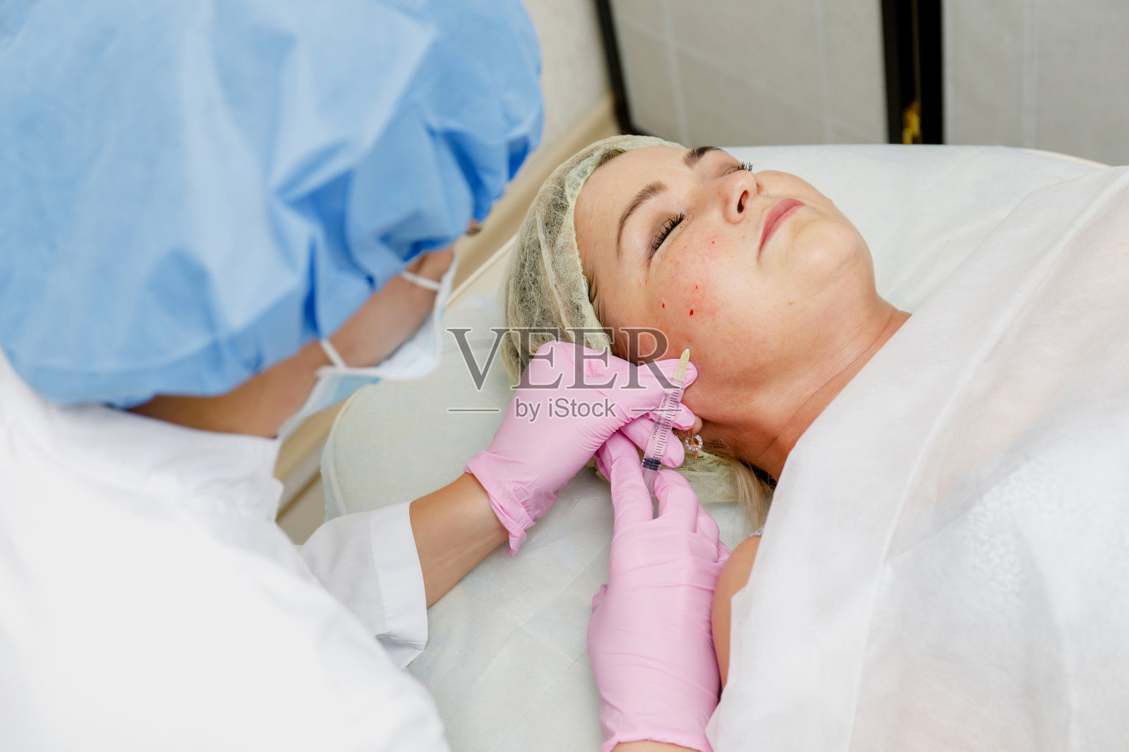 美容师做面部注射。抗衰老再生美容程序照片摄影图片