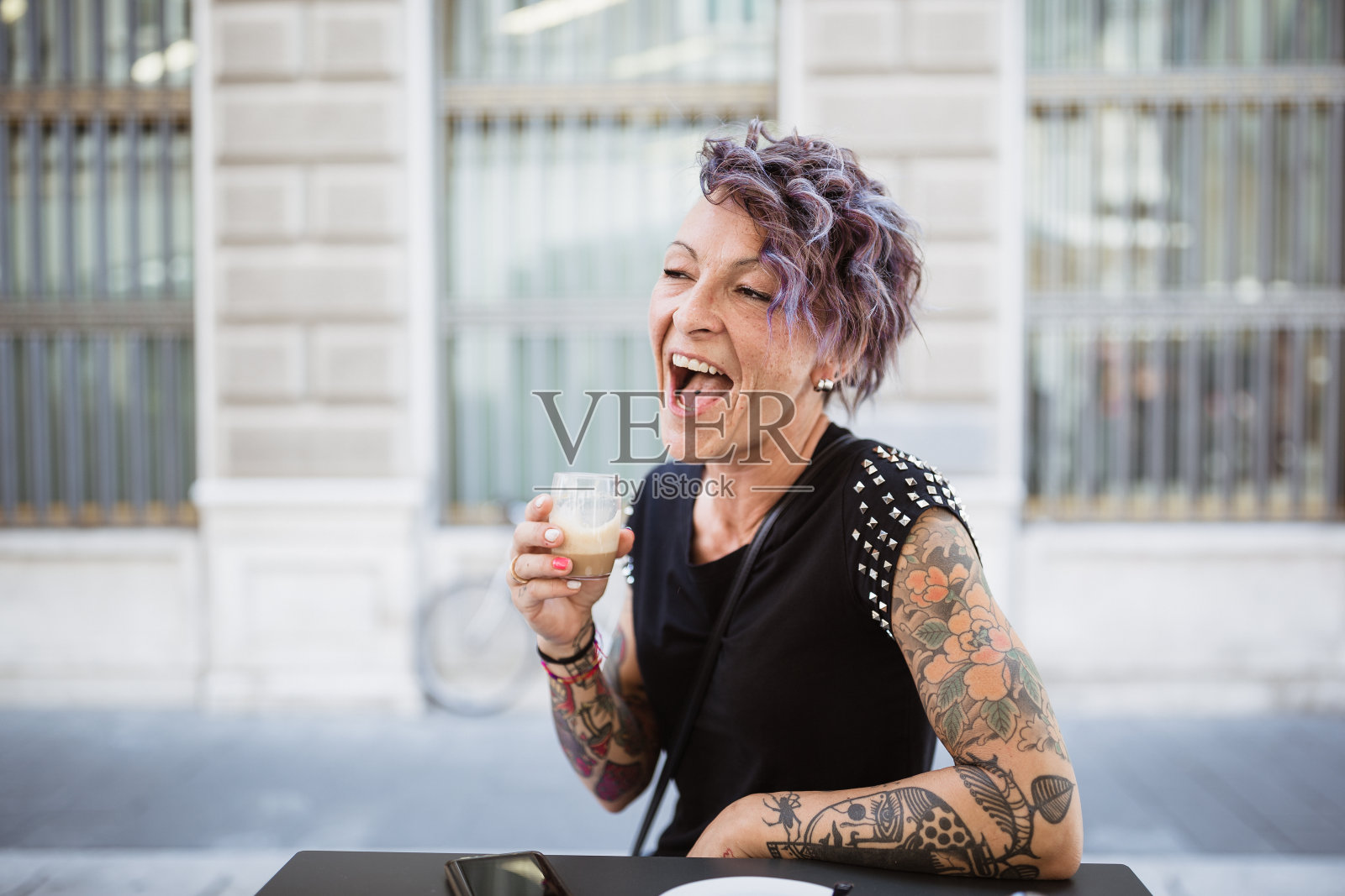 一个意大利女人，坐在户外的咖啡馆里照片摄影图片