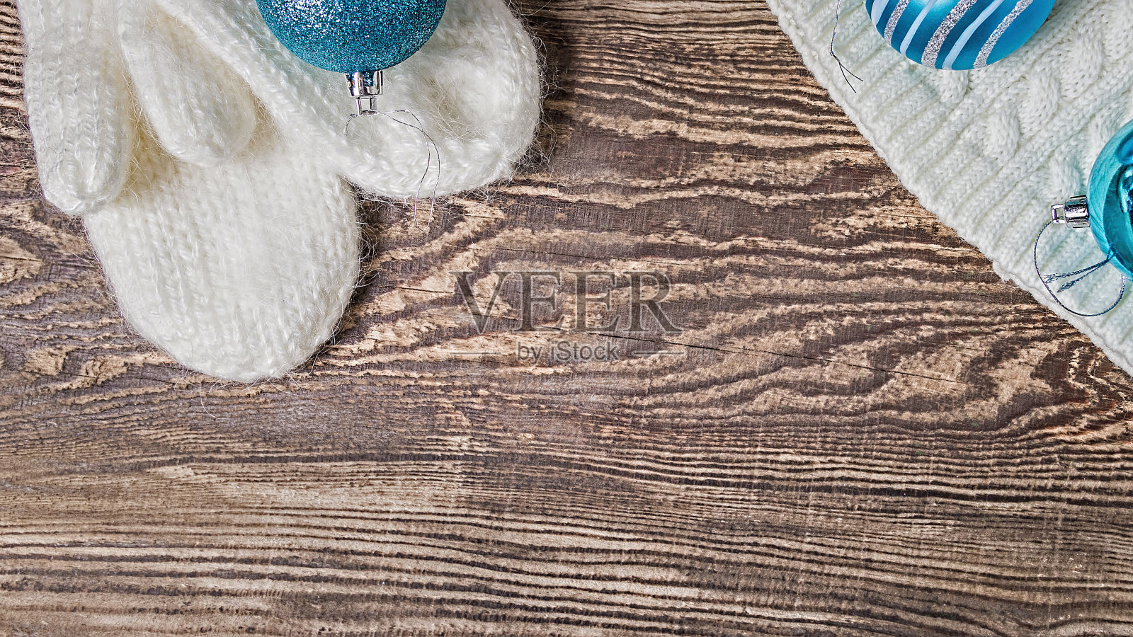 圣诞节的旗帜。冬天的背景。白色的手套和帽子放在一张木桌上。蓝色的球。照片摄影图片