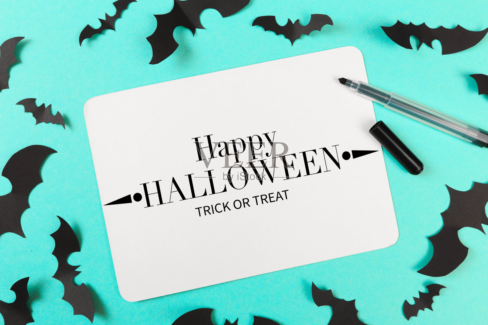 彩色蓝色背景的万圣节纸装饰。万圣节的概念。平铺，俯视图，拷贝空间照片摄影图片